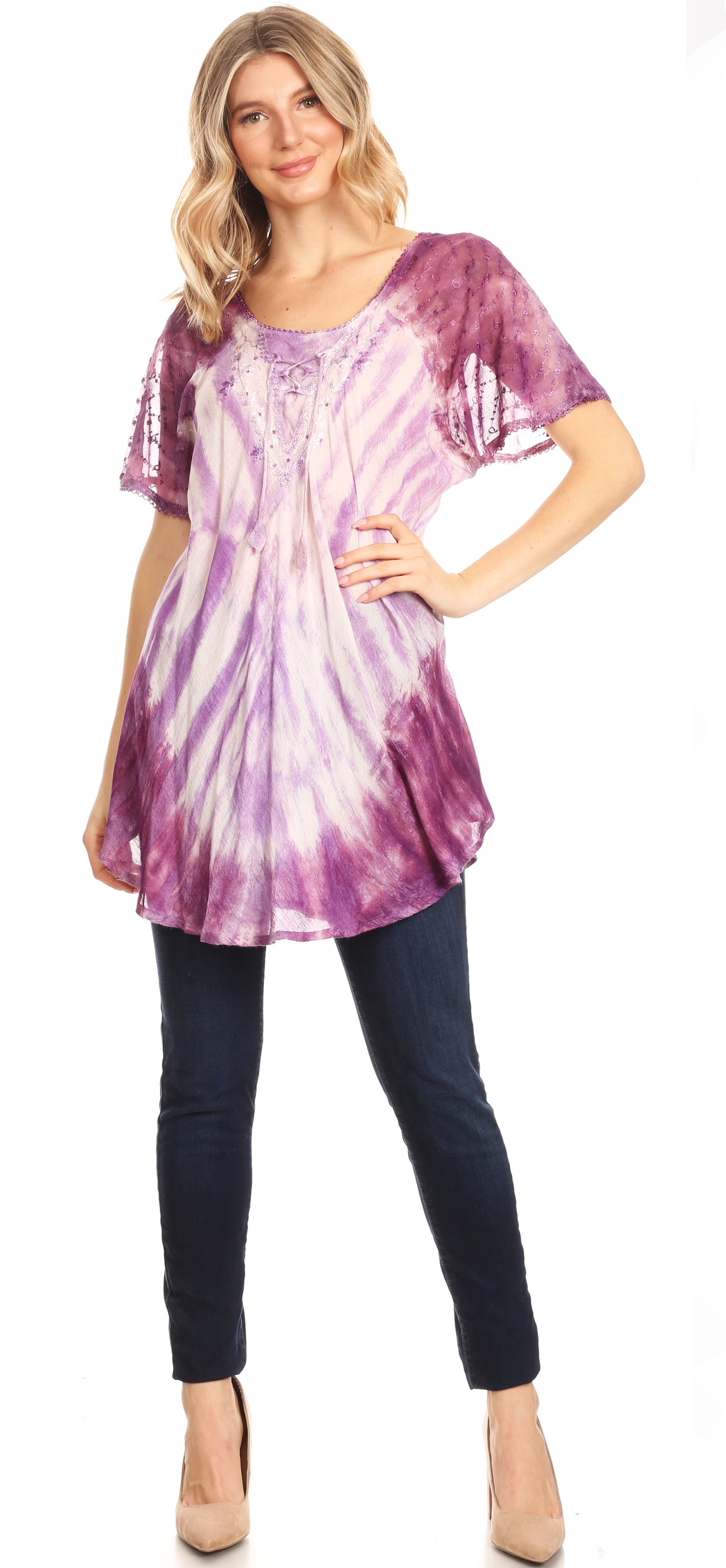 Woman wearing a purple tie-dye tunic and black pants, standing against a plain background.