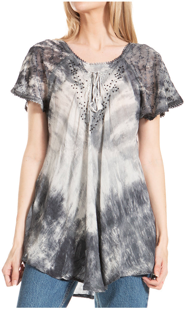 Woman wearing a tie-dye blouse with floral lace sleeves on a white background