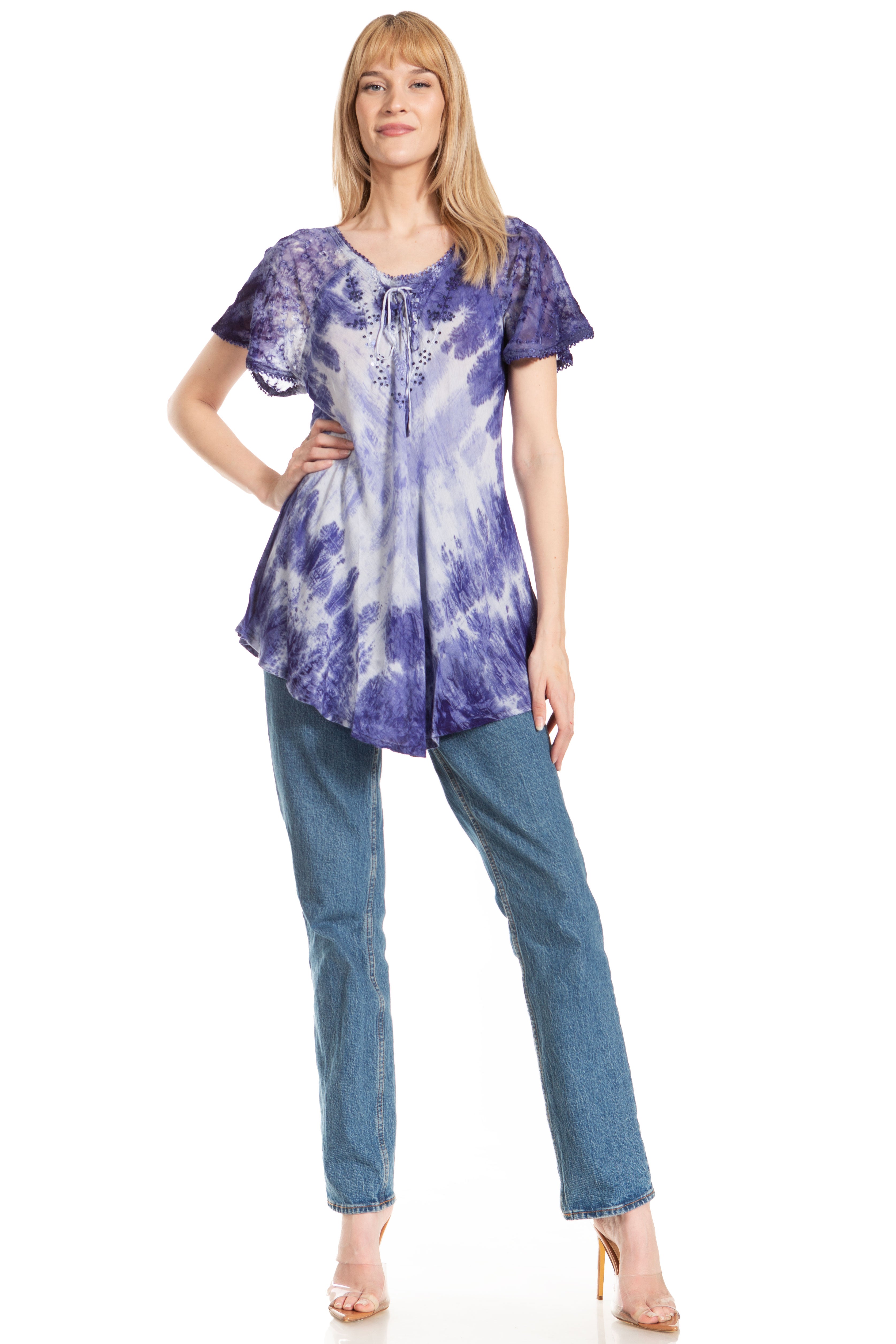 Woman wearing a purple tie-dye shirt and blue jeans on a white background