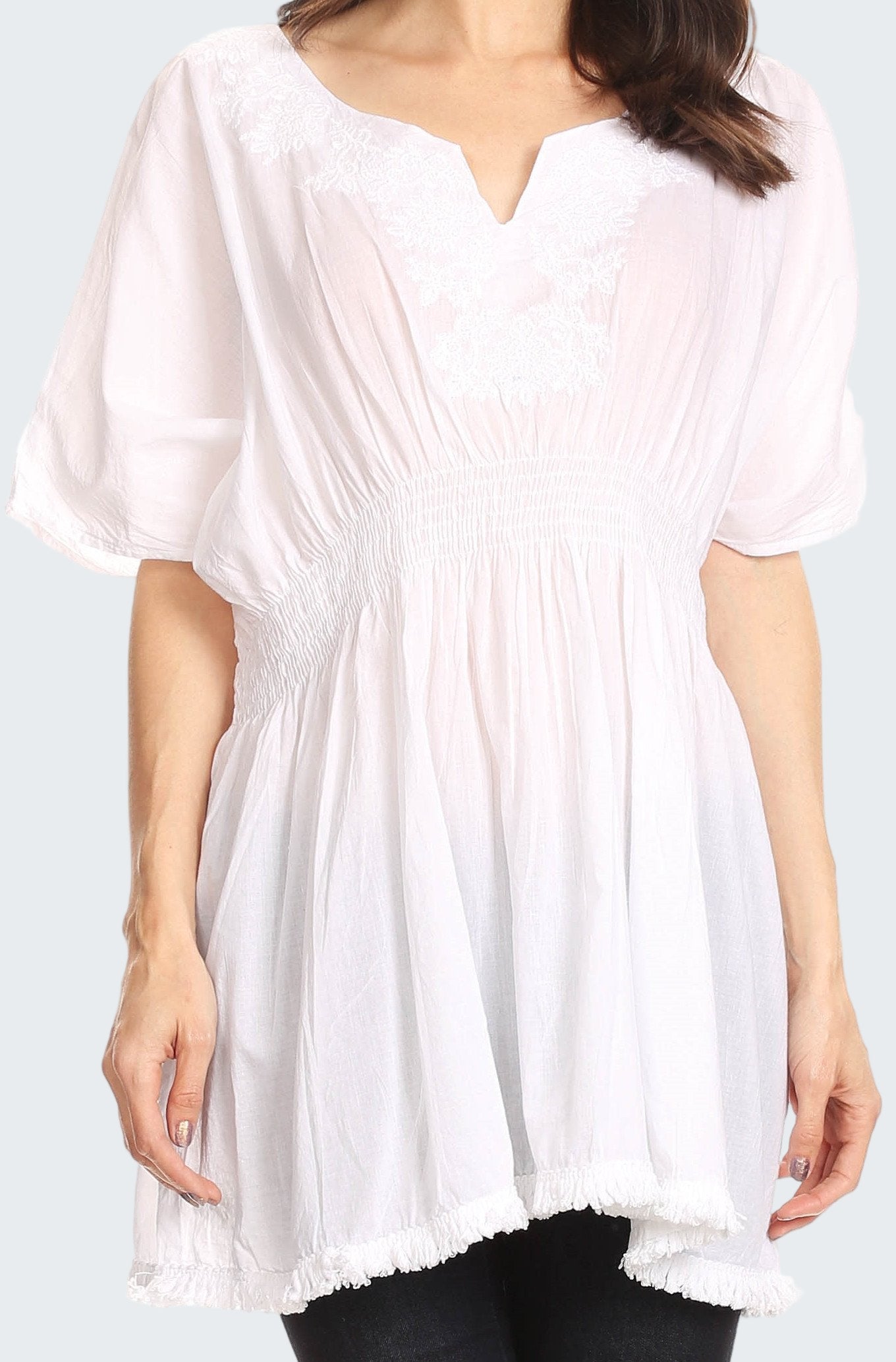 White tunic worn by a person on a plain background