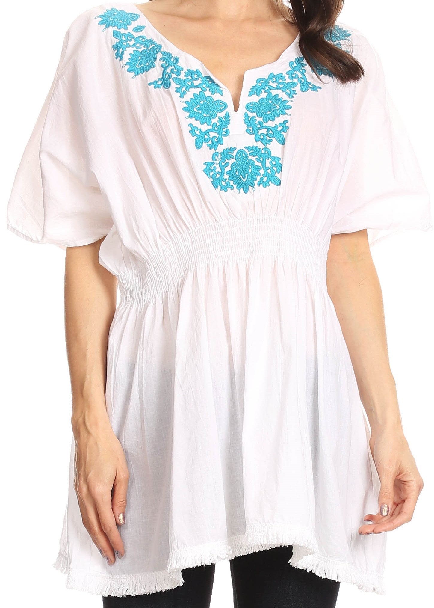 White tunic with blue floral embroidery on a white background
