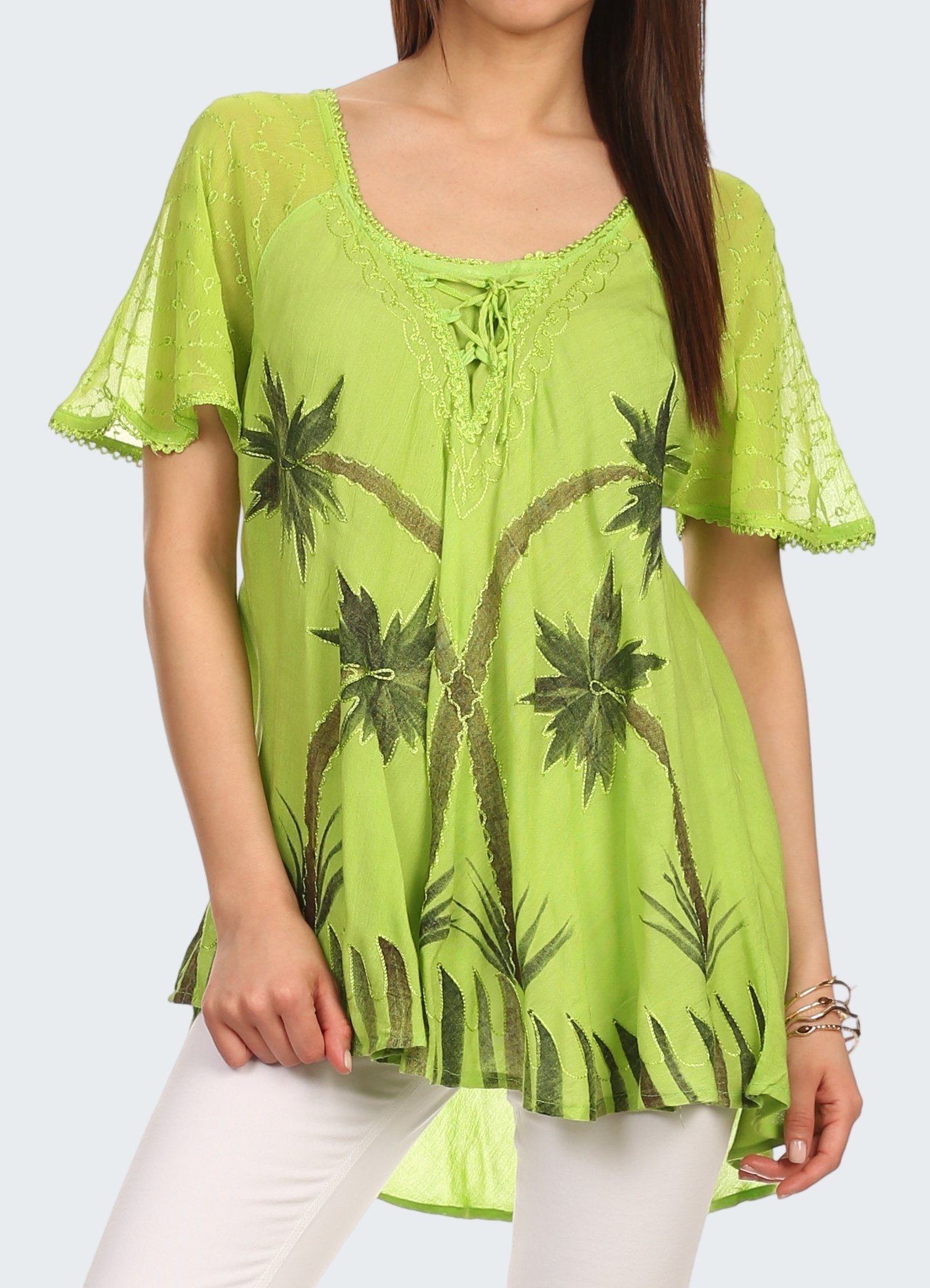 Woman wearing a green lace top with palm tree patterns on a white background