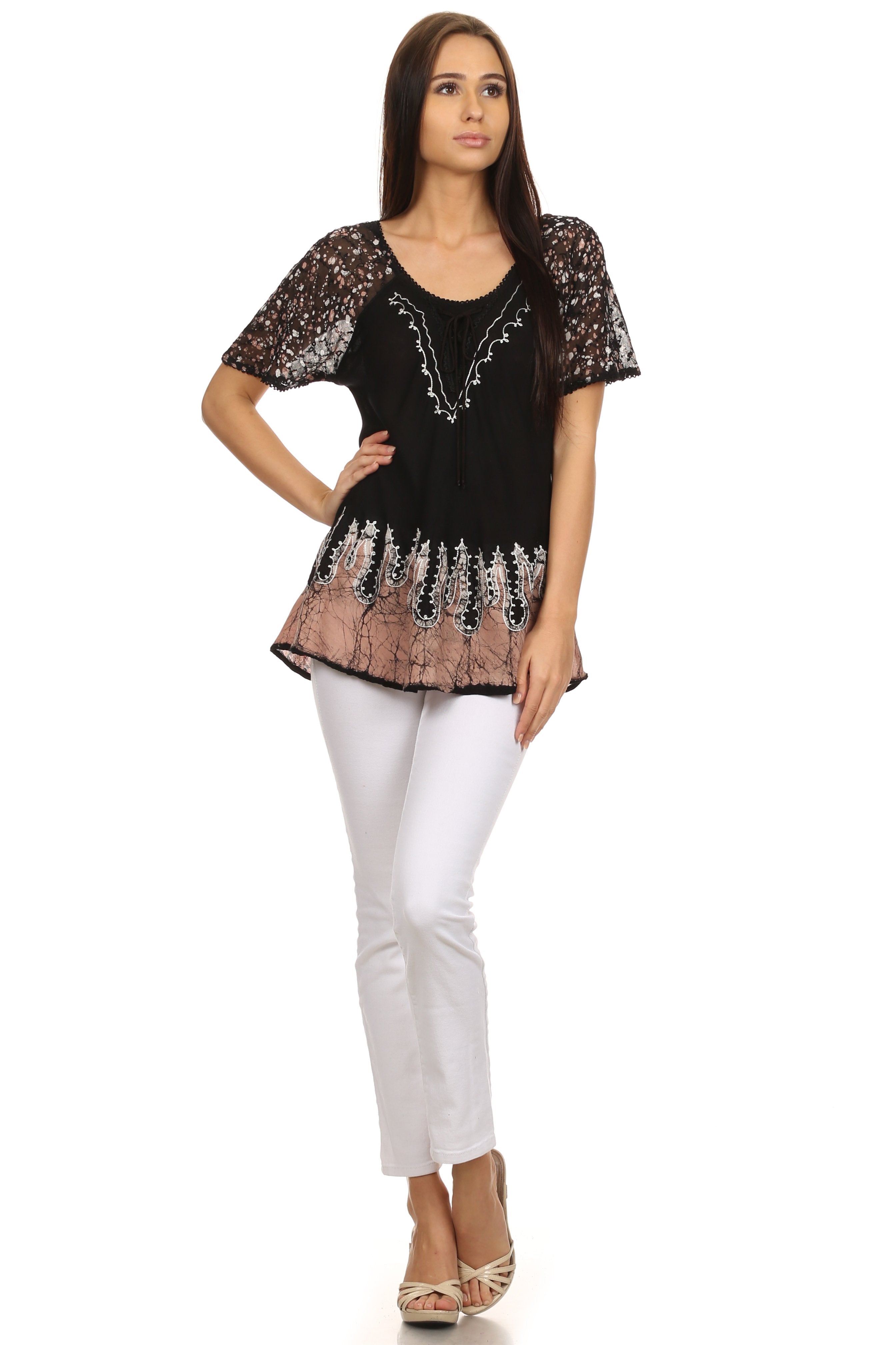 Woman wearing a black and brown patterned top with white pants on a white background