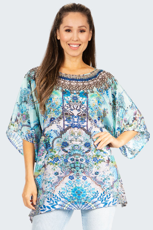 Woman wearing a colorful patterned blouse on a white background