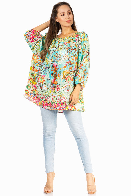 Woman wearing a colorful floral dress with light blue pants on a white background