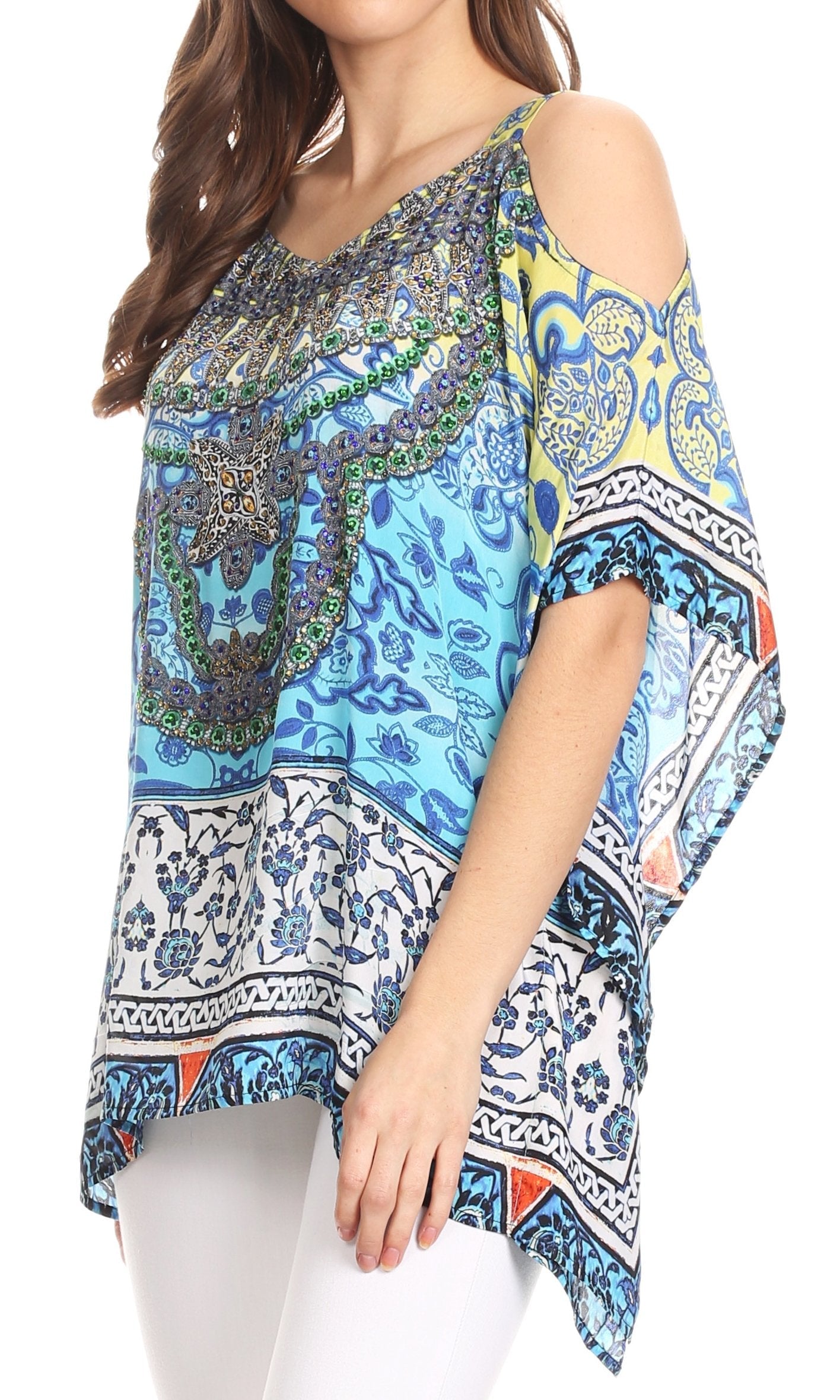 Woman wearing a colorful patterned top with white pants on a white background