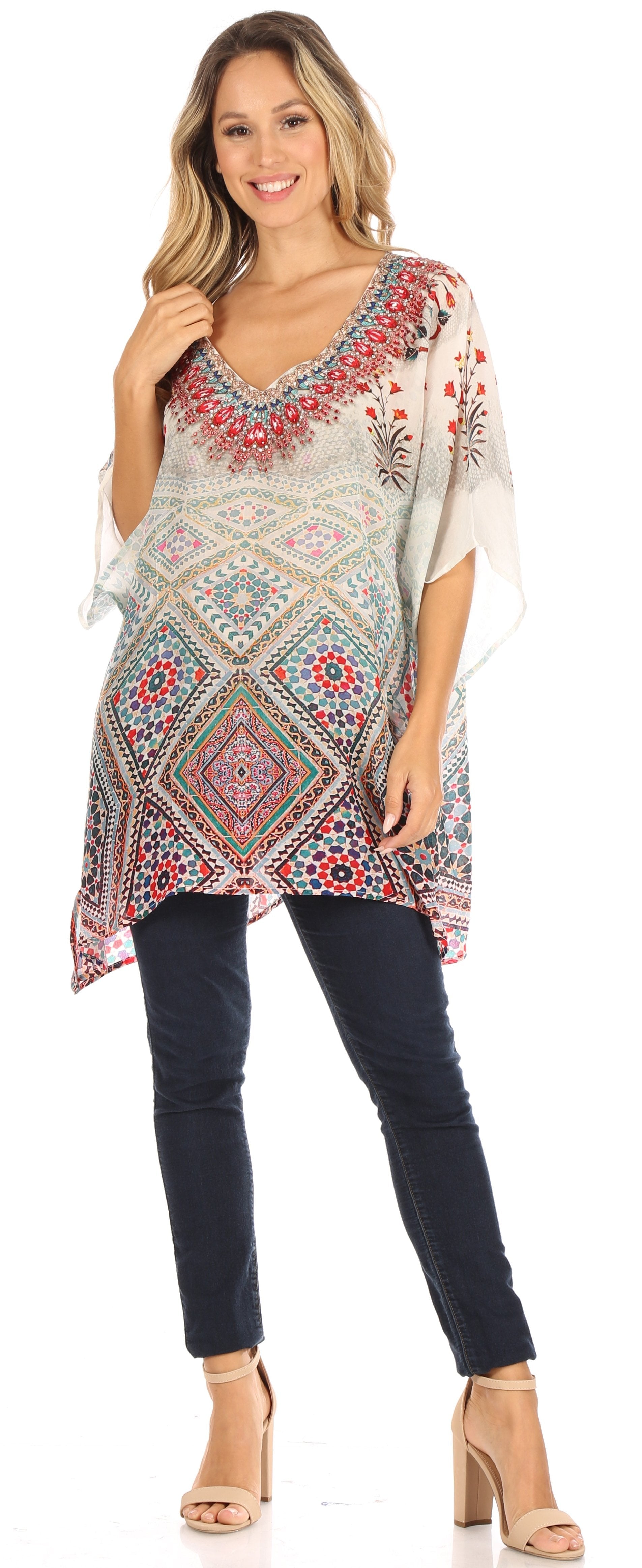 Woman wearing a patterned top and dark jeans on a white background
