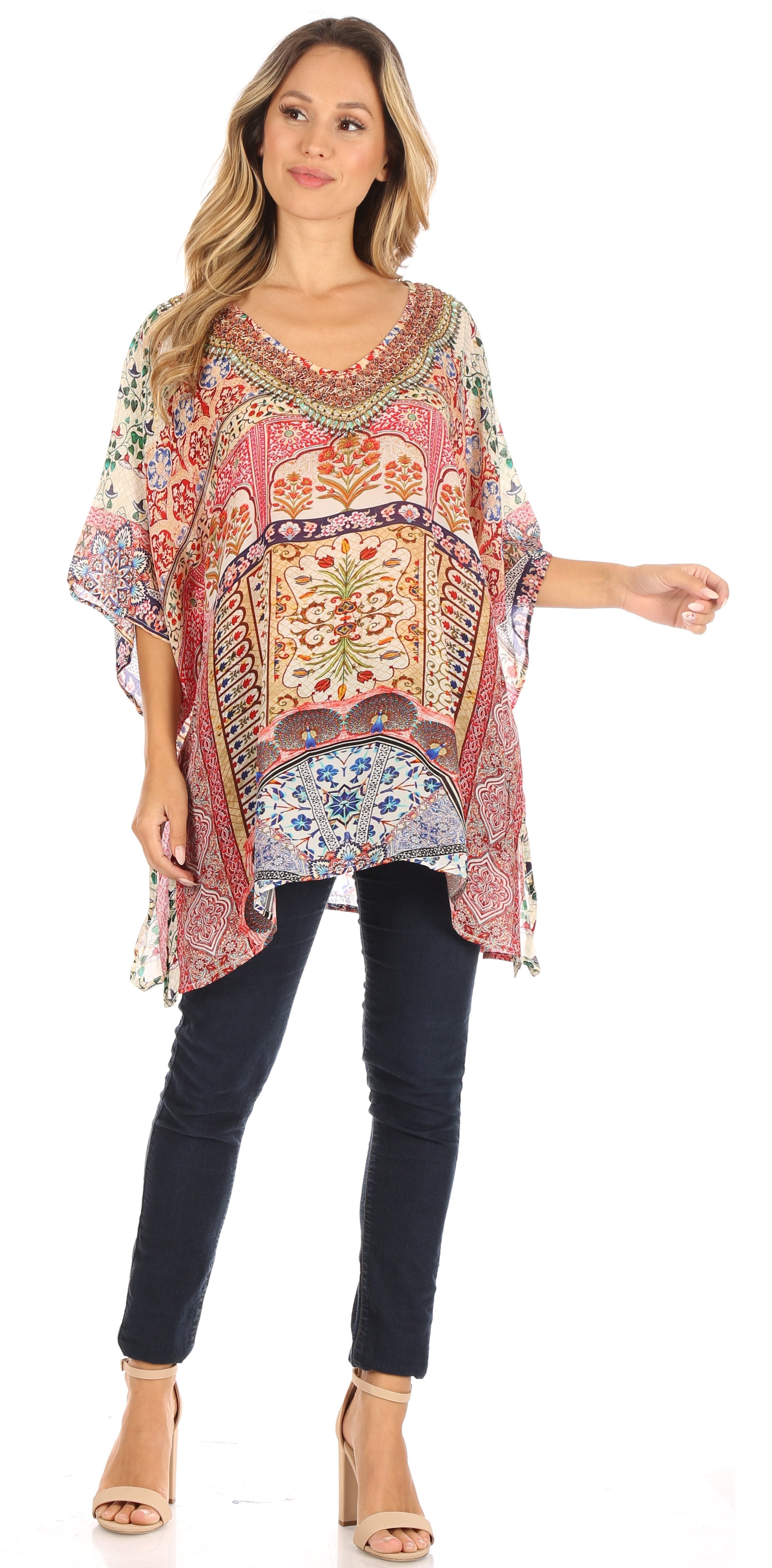 Woman wearing a colorful patterned top and dark jeans on a white background