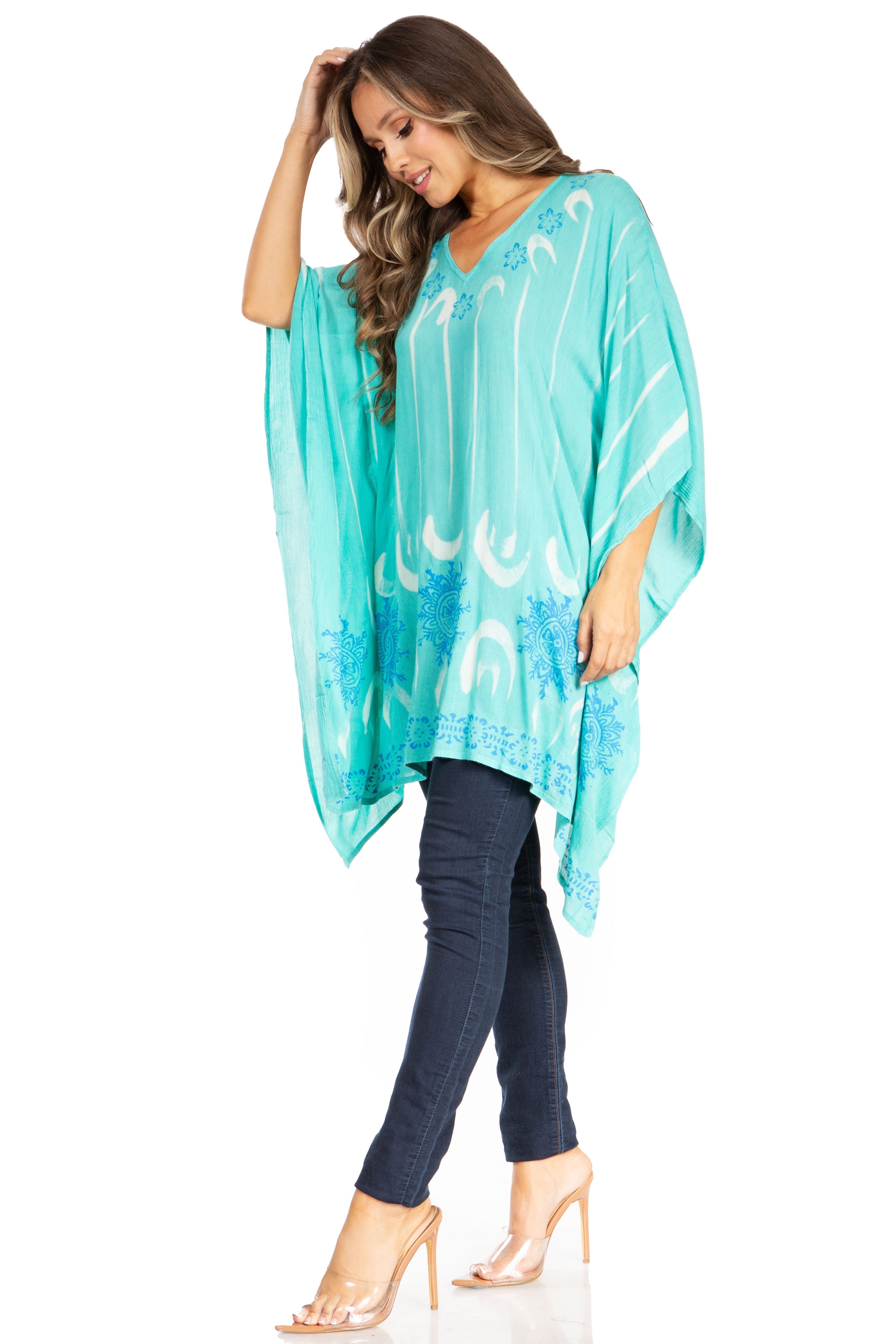 Woman wearing a turquoise kimono-style garment with white patterns on a white background