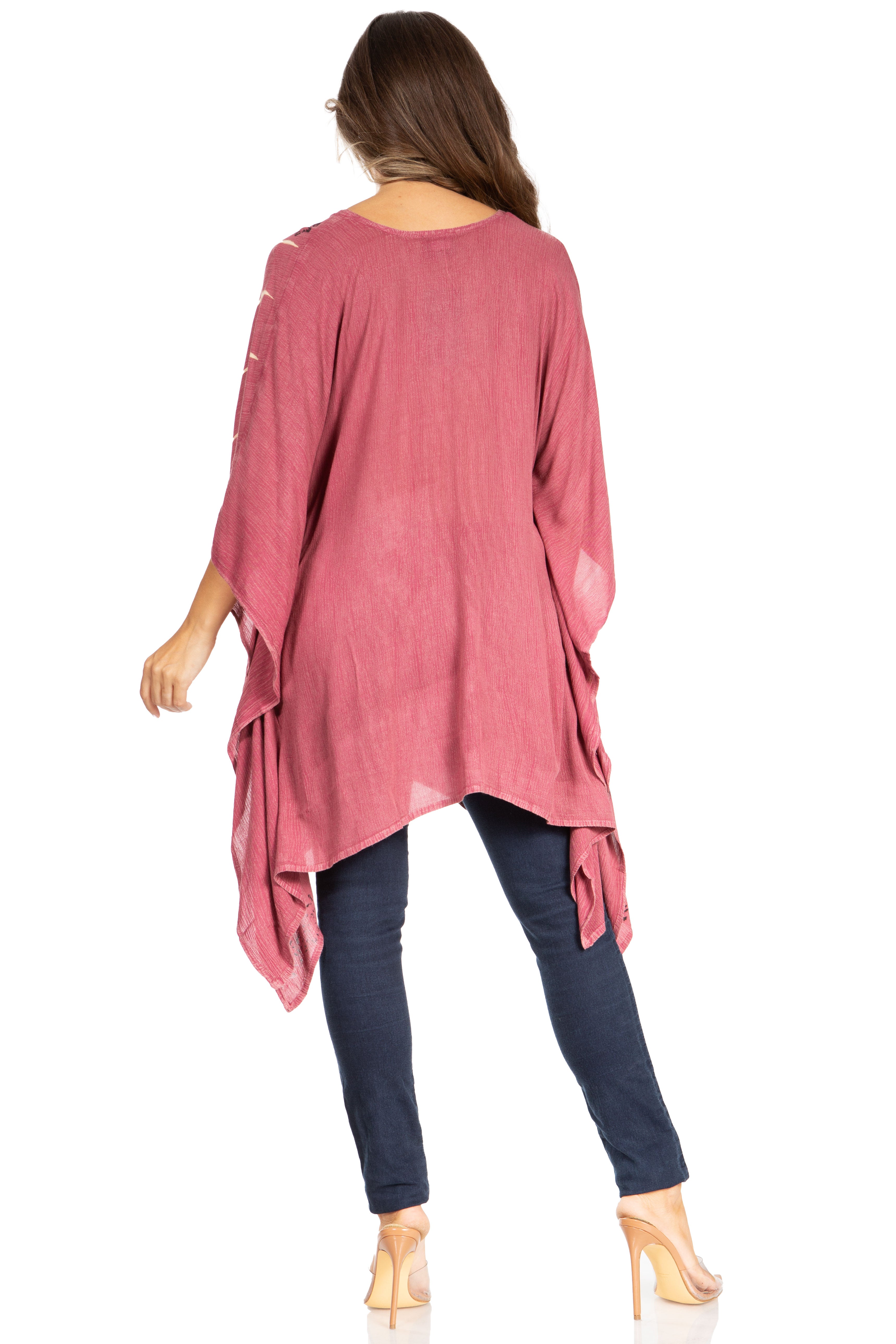 Woman wearing a pink long-sleeve top and dark pants on a white background