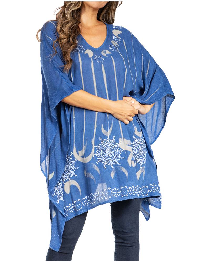 Blue poncho with white patterns worn by a person on a white background