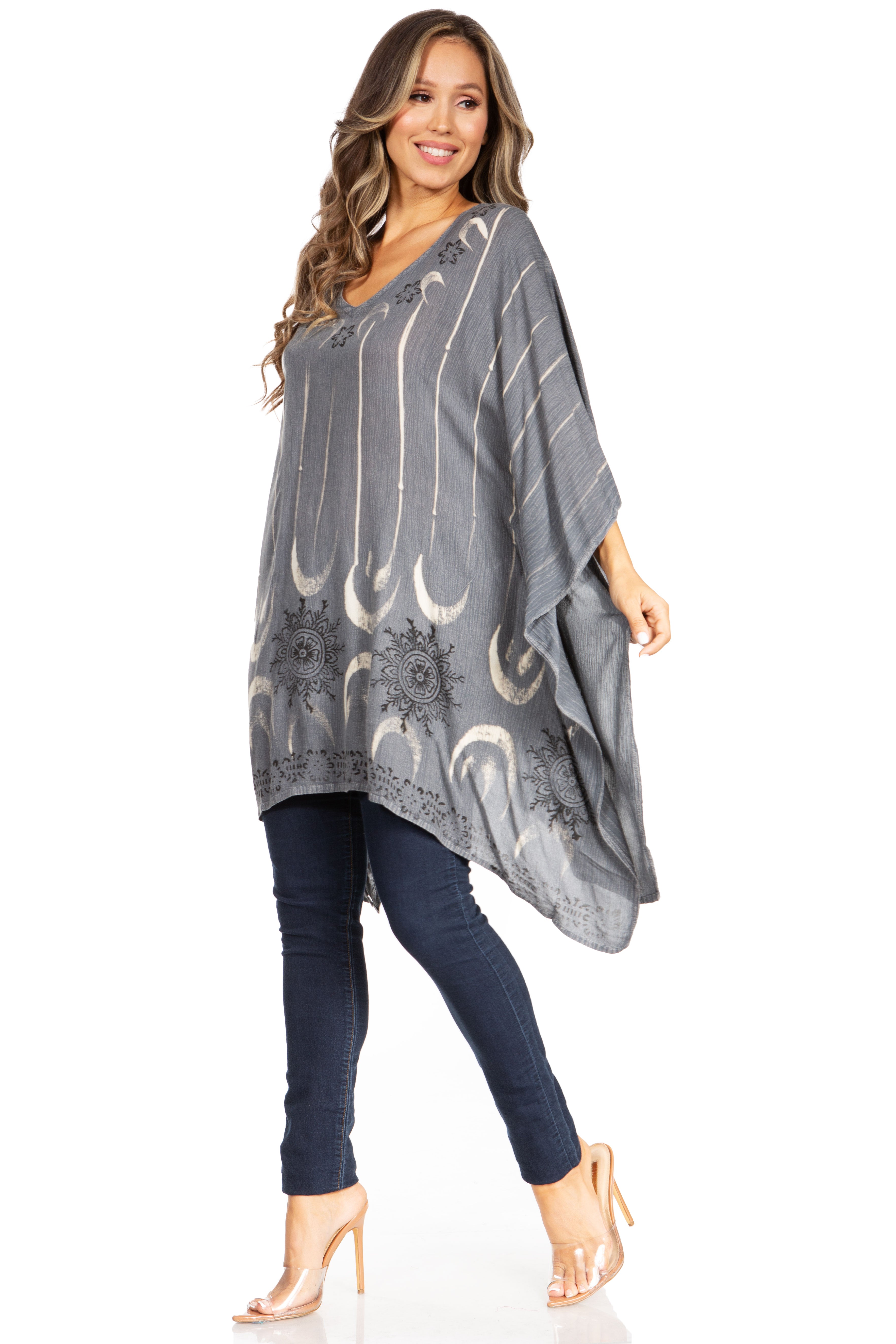 Woman wearing a gray poncho with white patterns on a white background