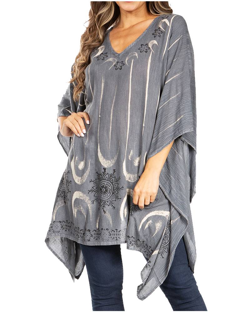 Gray poncho with white patterns worn by a person on a white background