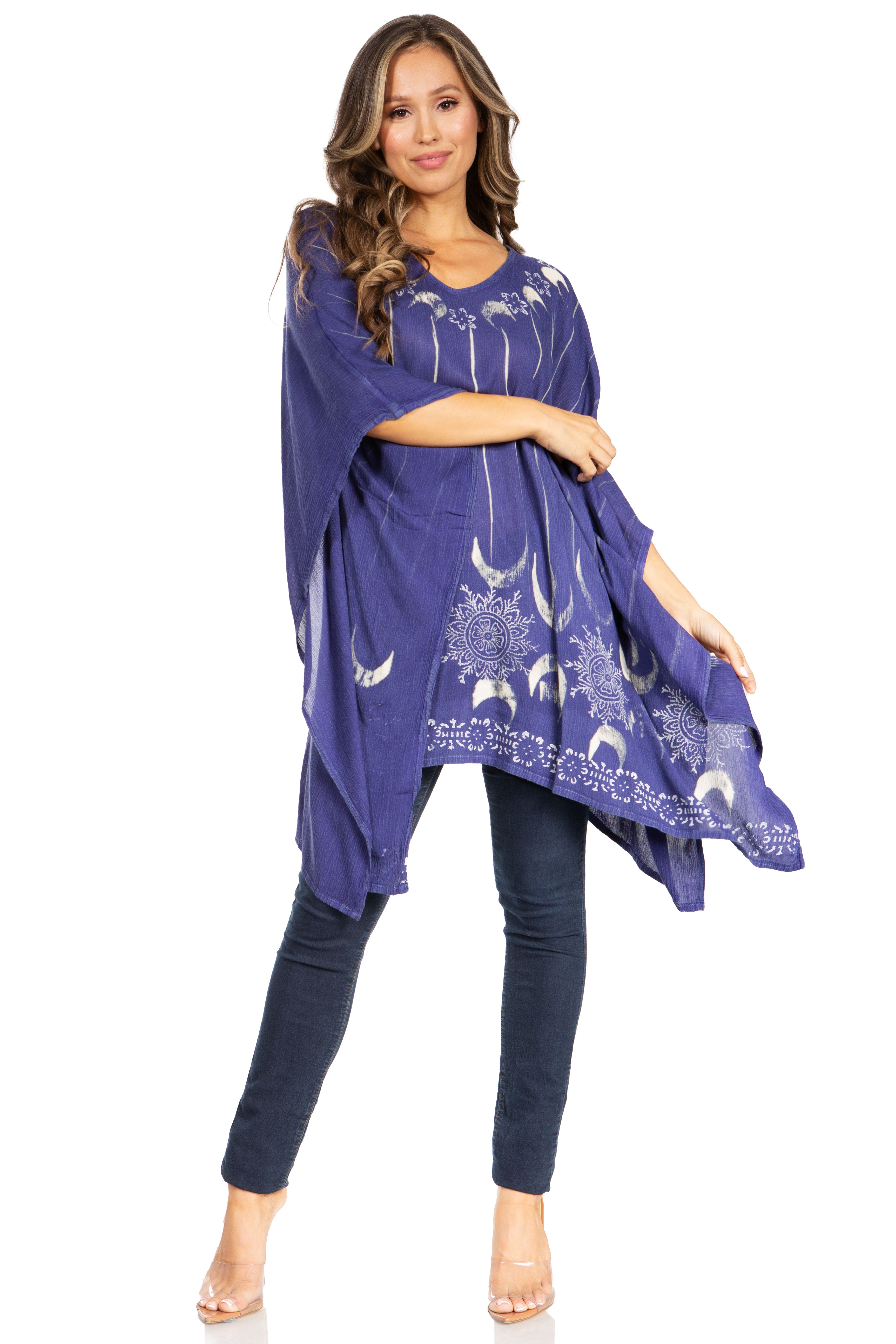 Woman wearing a blue poncho with white patterns on a white background