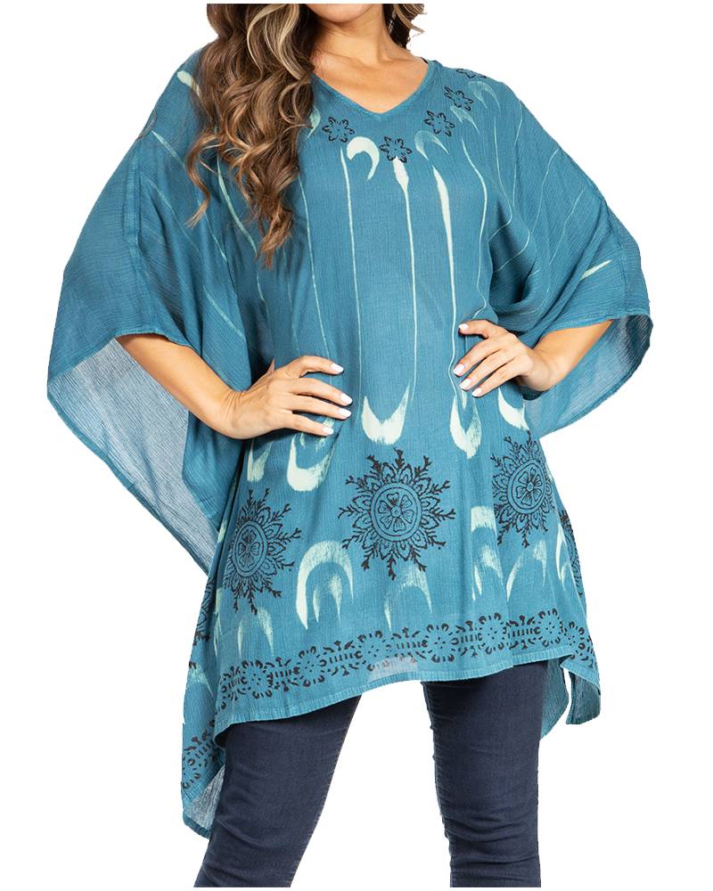 Woman wearing a blue poncho with white patterns on a white background