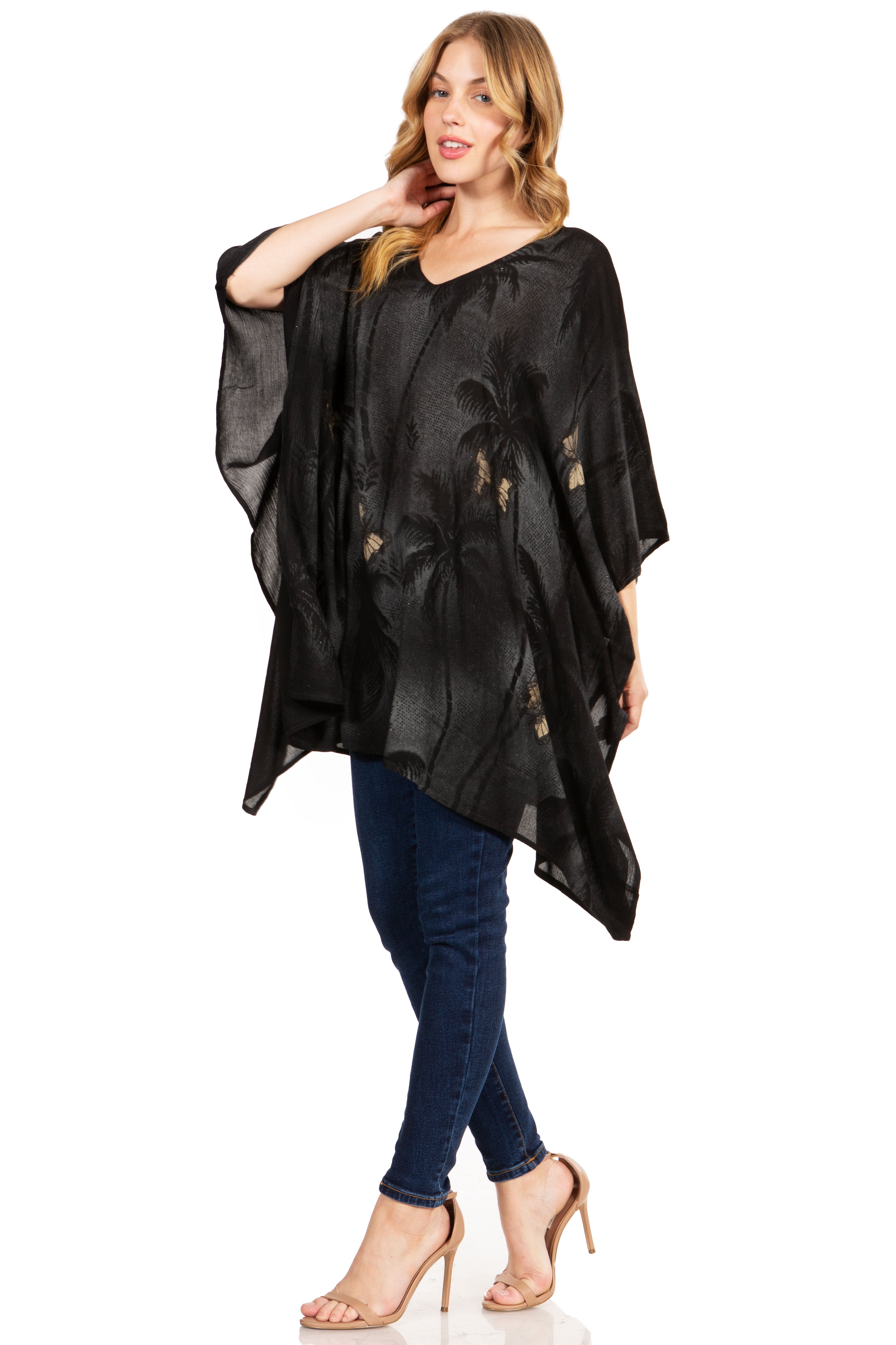 Woman wearing a black poncho over a blue outfit on a white background
