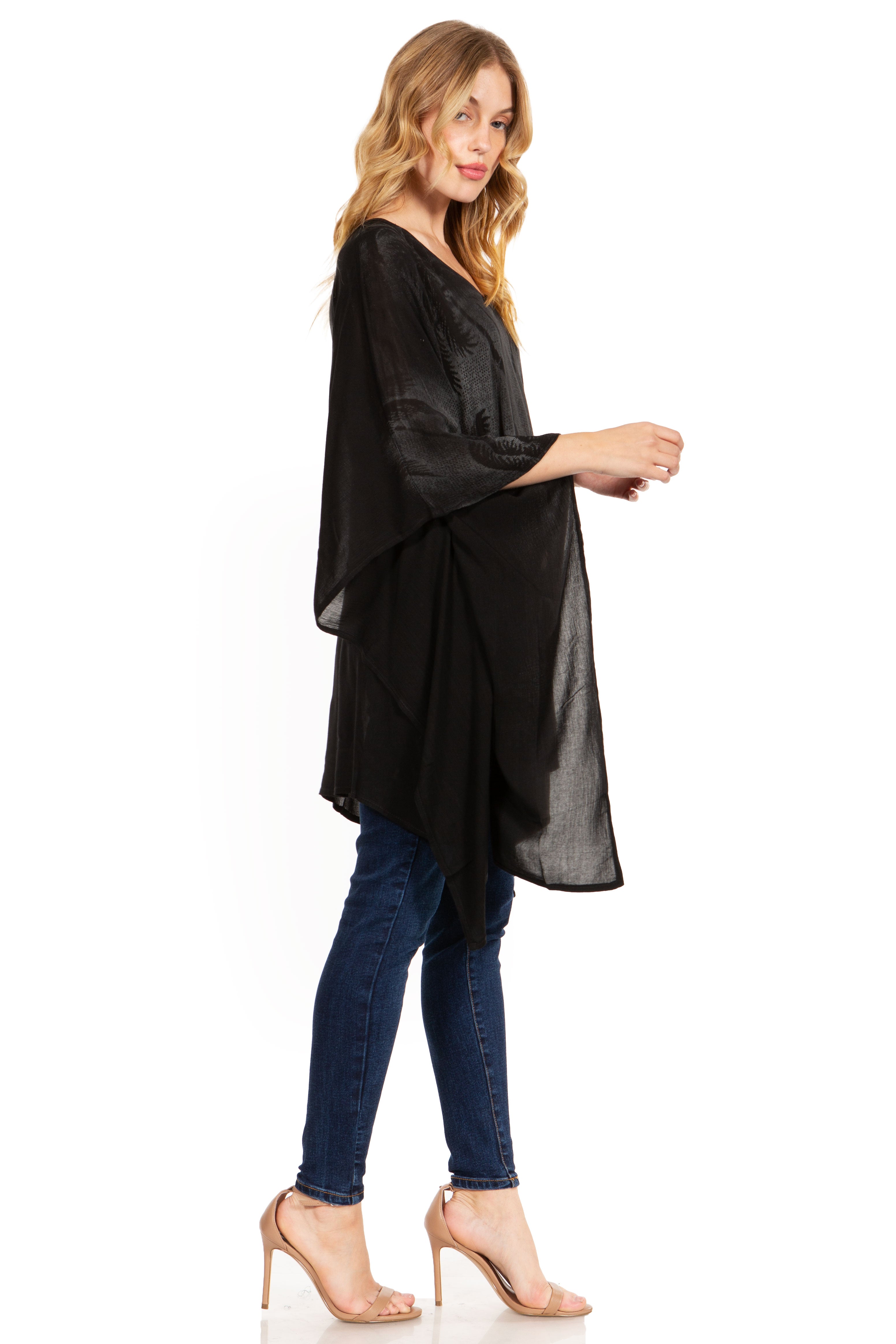 Woman wearing a black oversized top and blue jeans on a white background