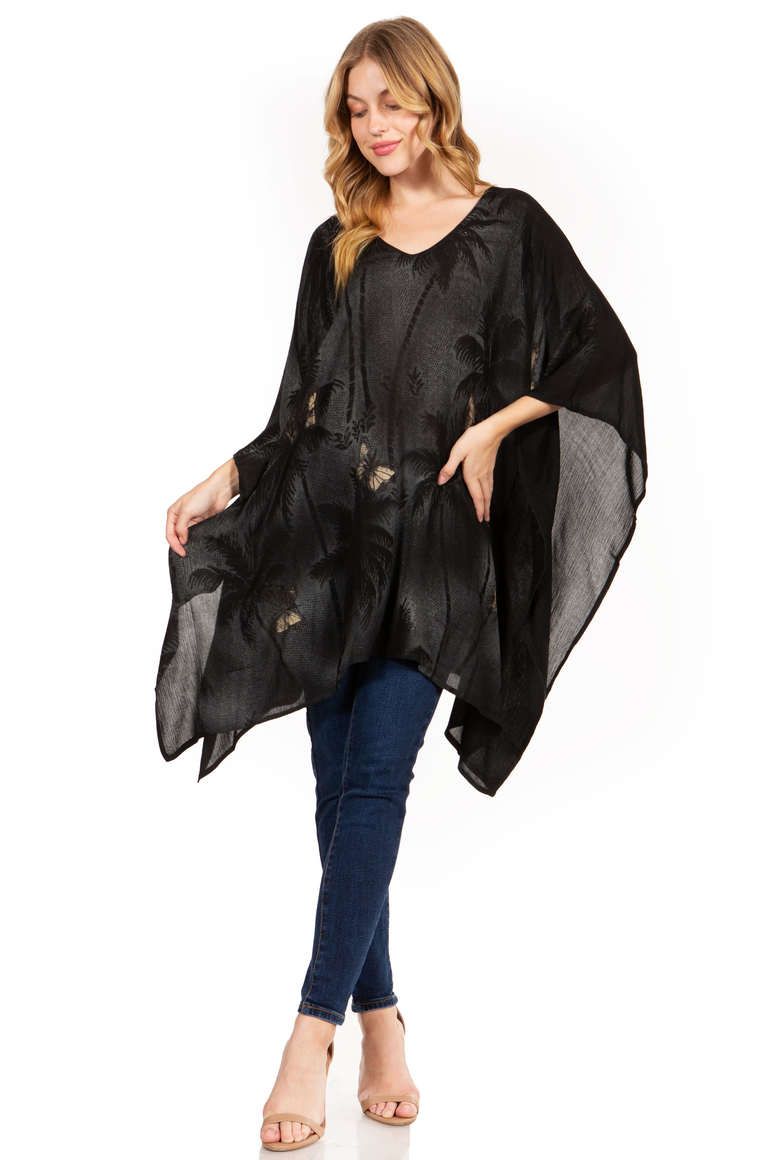 Woman wearing a black poncho over a blue outfit on a white background