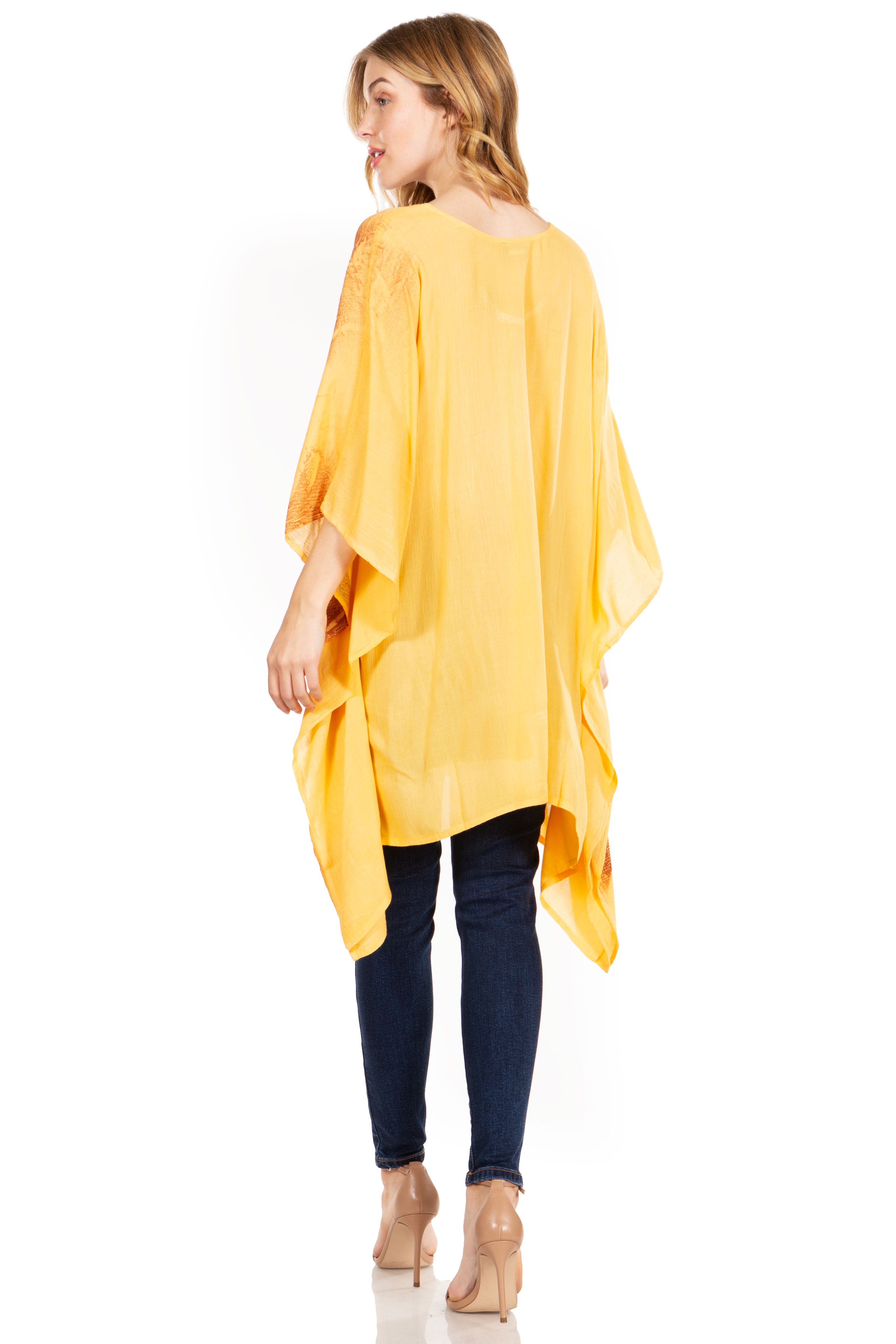 Woman wearing a yellow poncho over a white shirt and dark pants on a white background