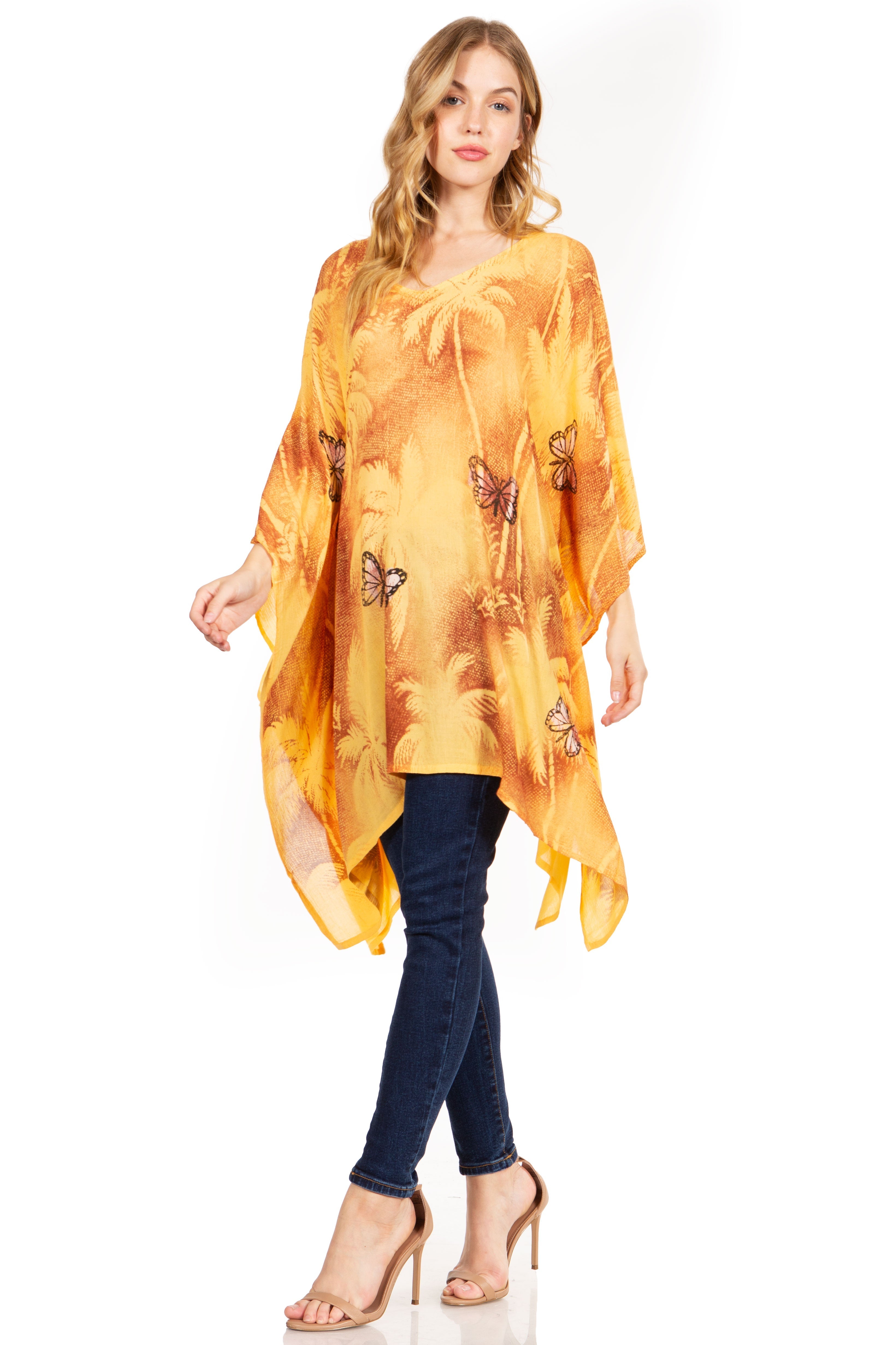 Woman wearing a yellow butterfly-patterned kimono over a dark top and jeans on a white background