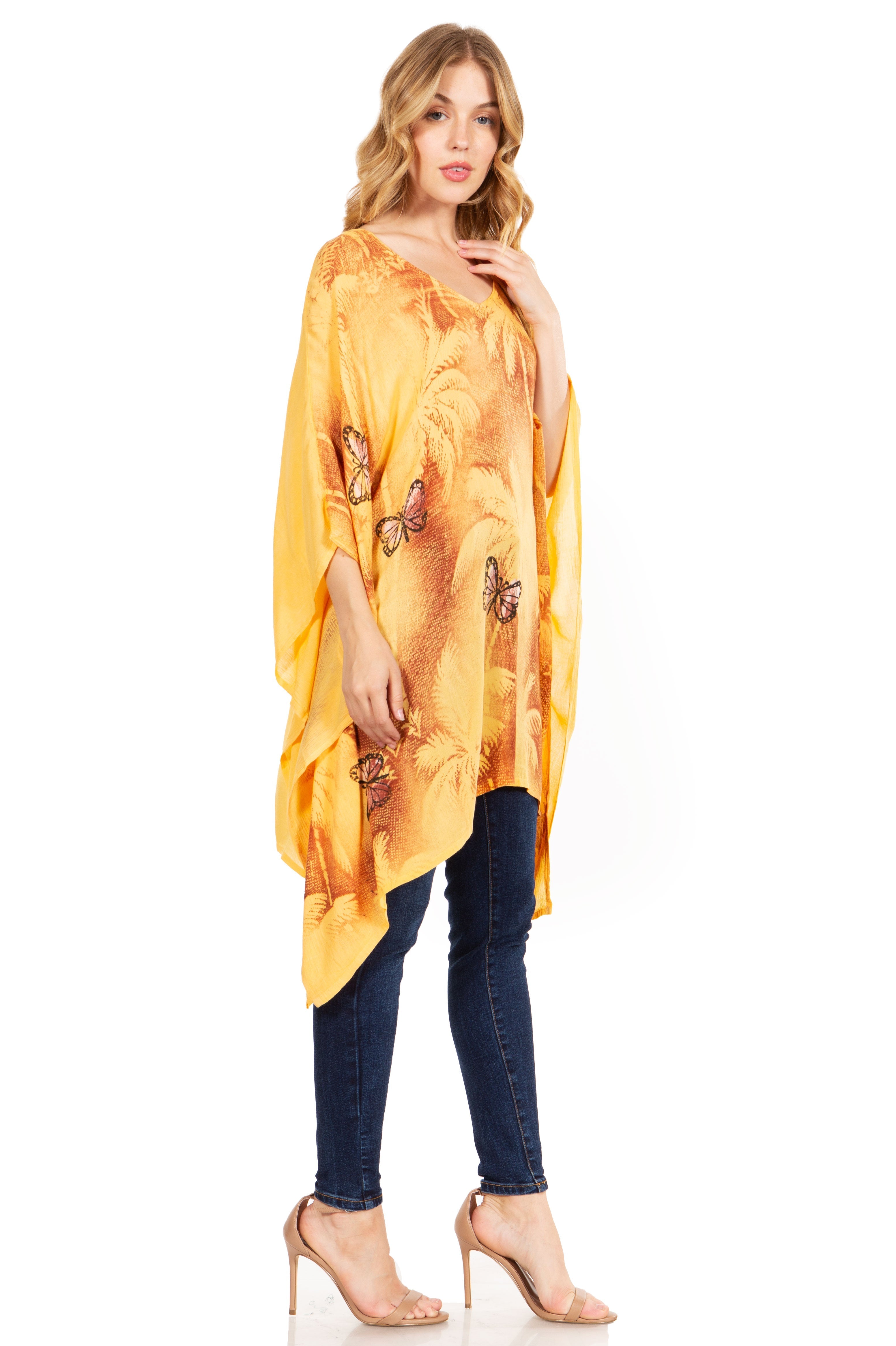 Woman wearing a yellow butterfly-patterned kimono over a dark top and jeans on a white background