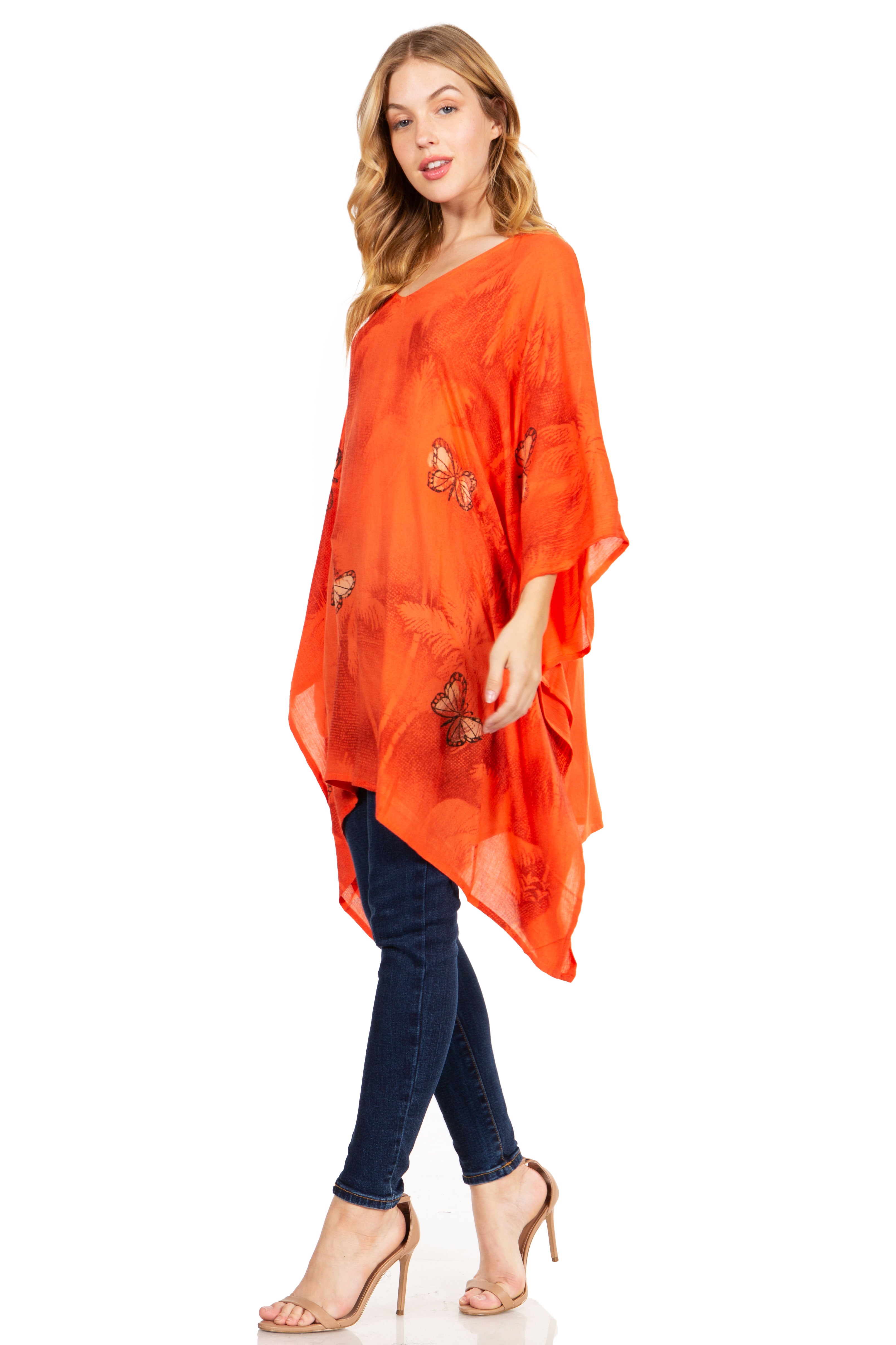 Woman wearing an orange poncho with butterfly patterns on a white background