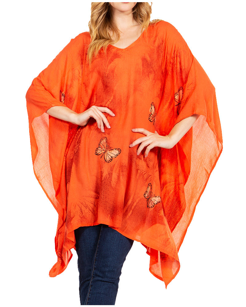 Orange poncho with butterfly designs worn by a person on a white background