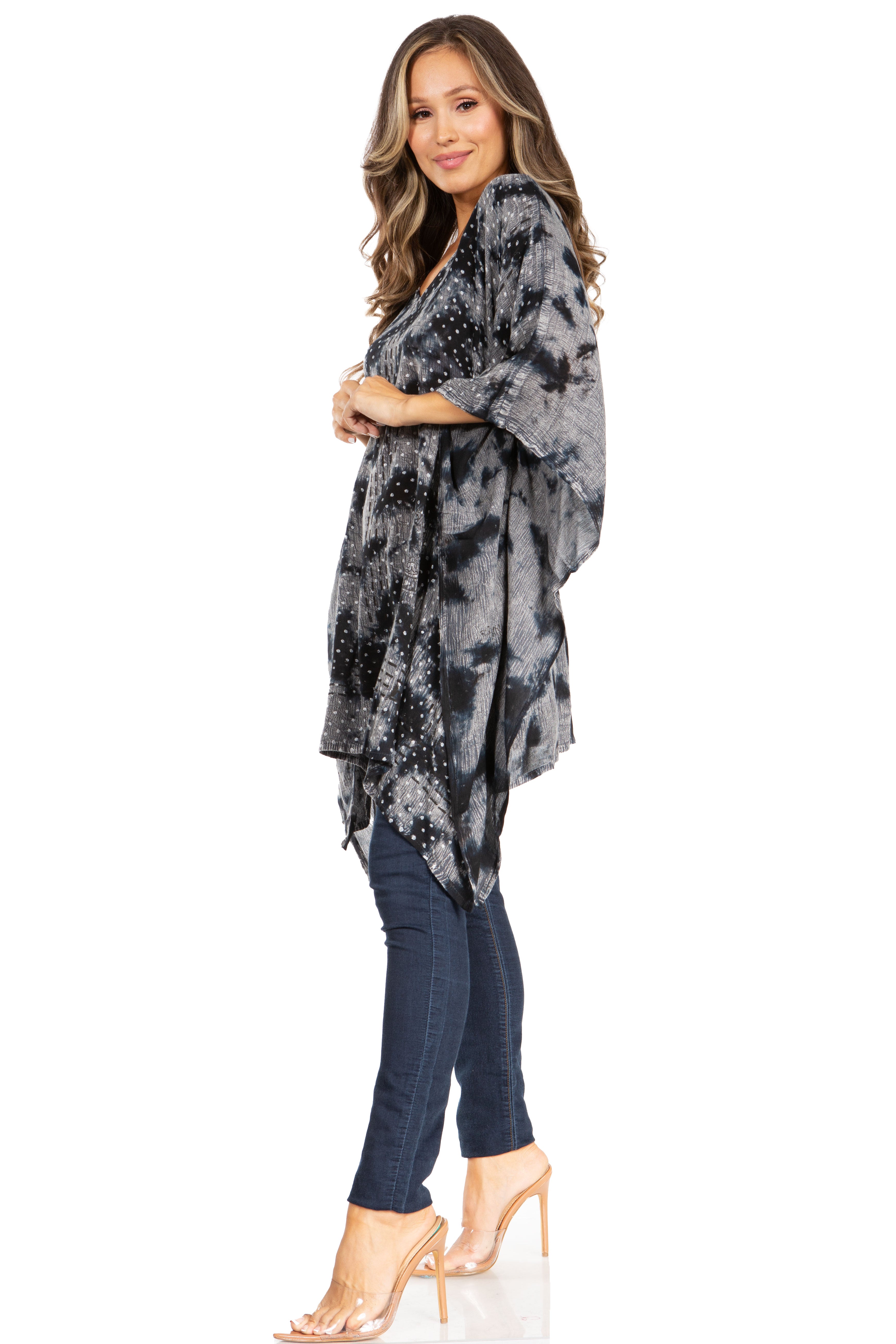Woman wearing a black and gray tie-dye dress over jeans on a white background