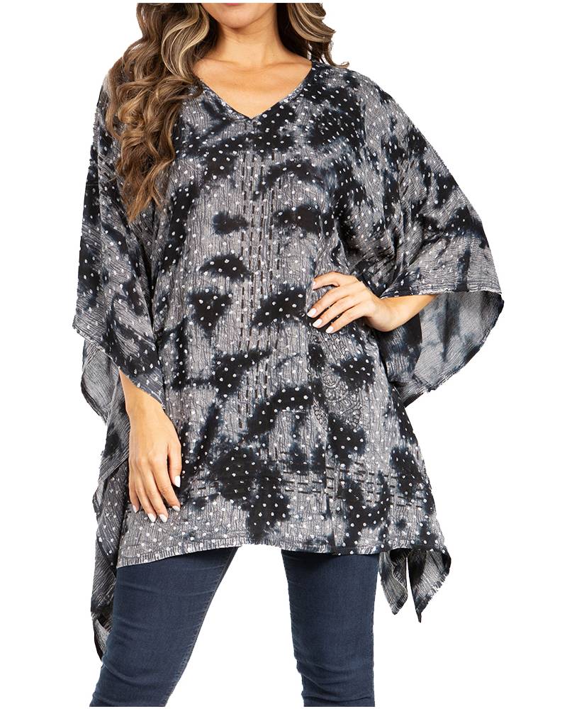 Woman wearing a black and gray patterned poncho over a dark outfit on a white background