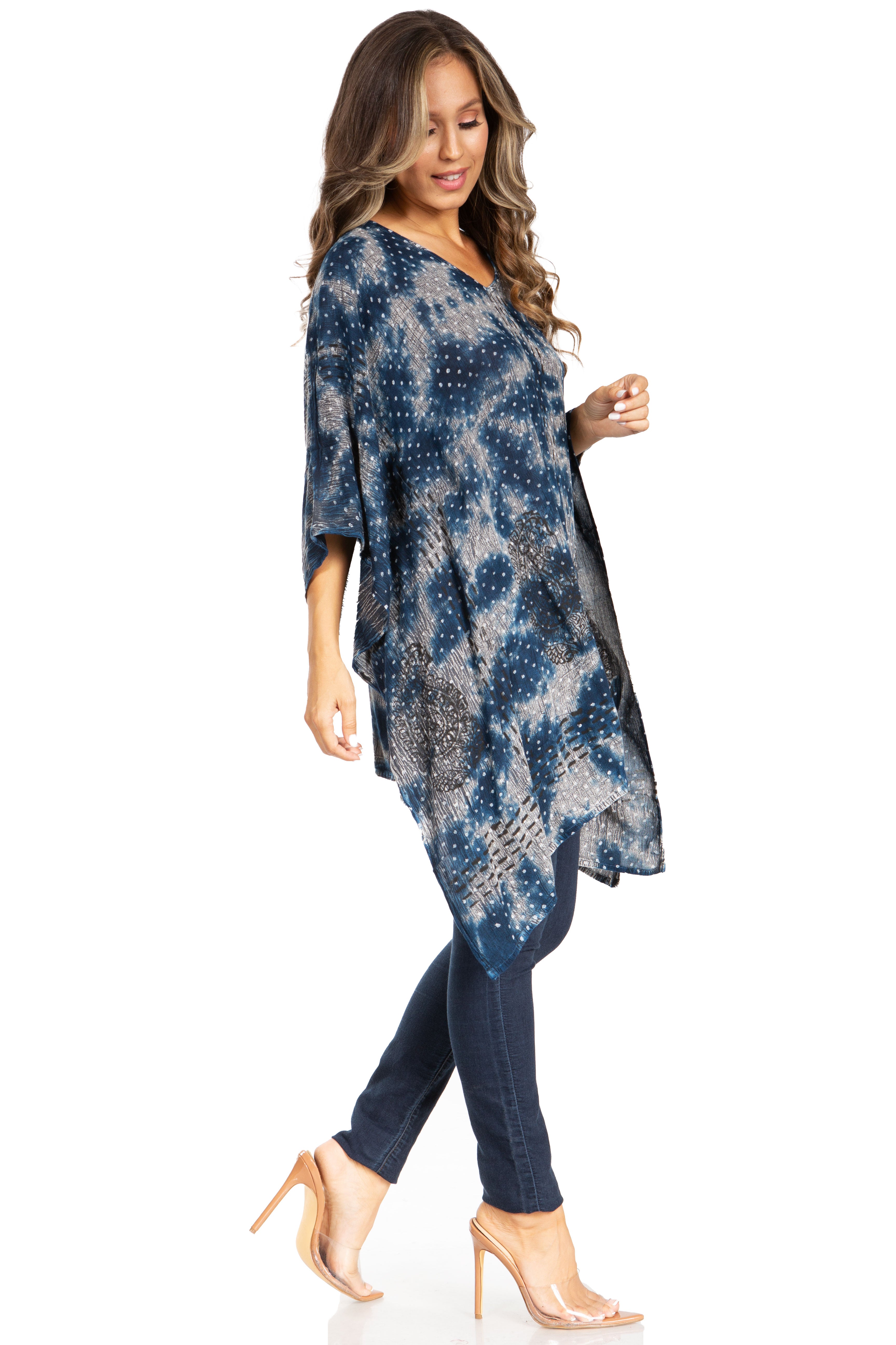 Woman wearing a blue patterned dress and jeans on a white background