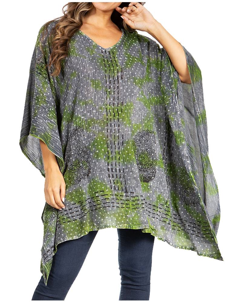 Woman wearing a patterned poncho with green and gray design on a white background