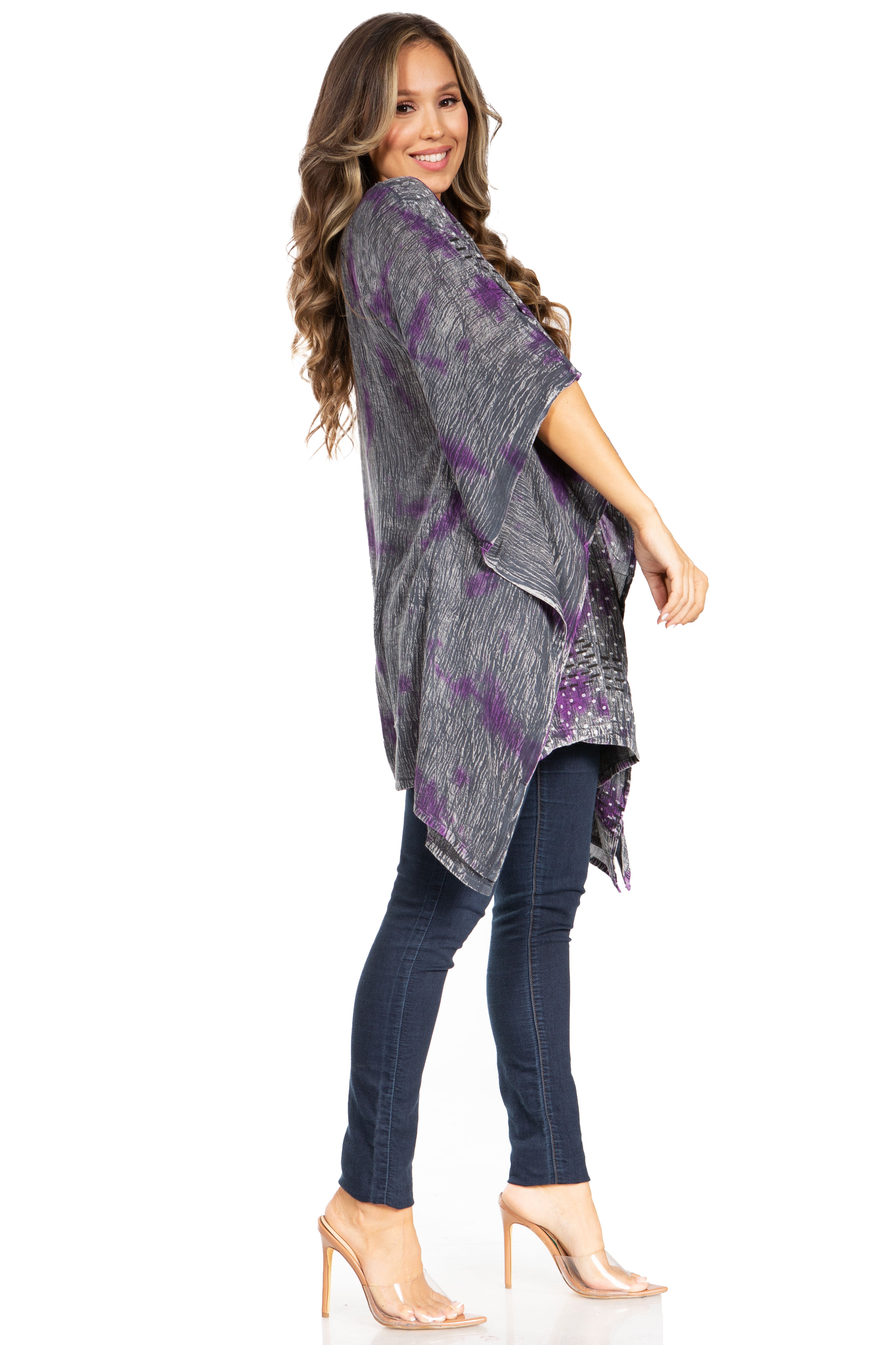 Woman wearing a gray and purple tie-dye kimono over a black top and jeans on a white background