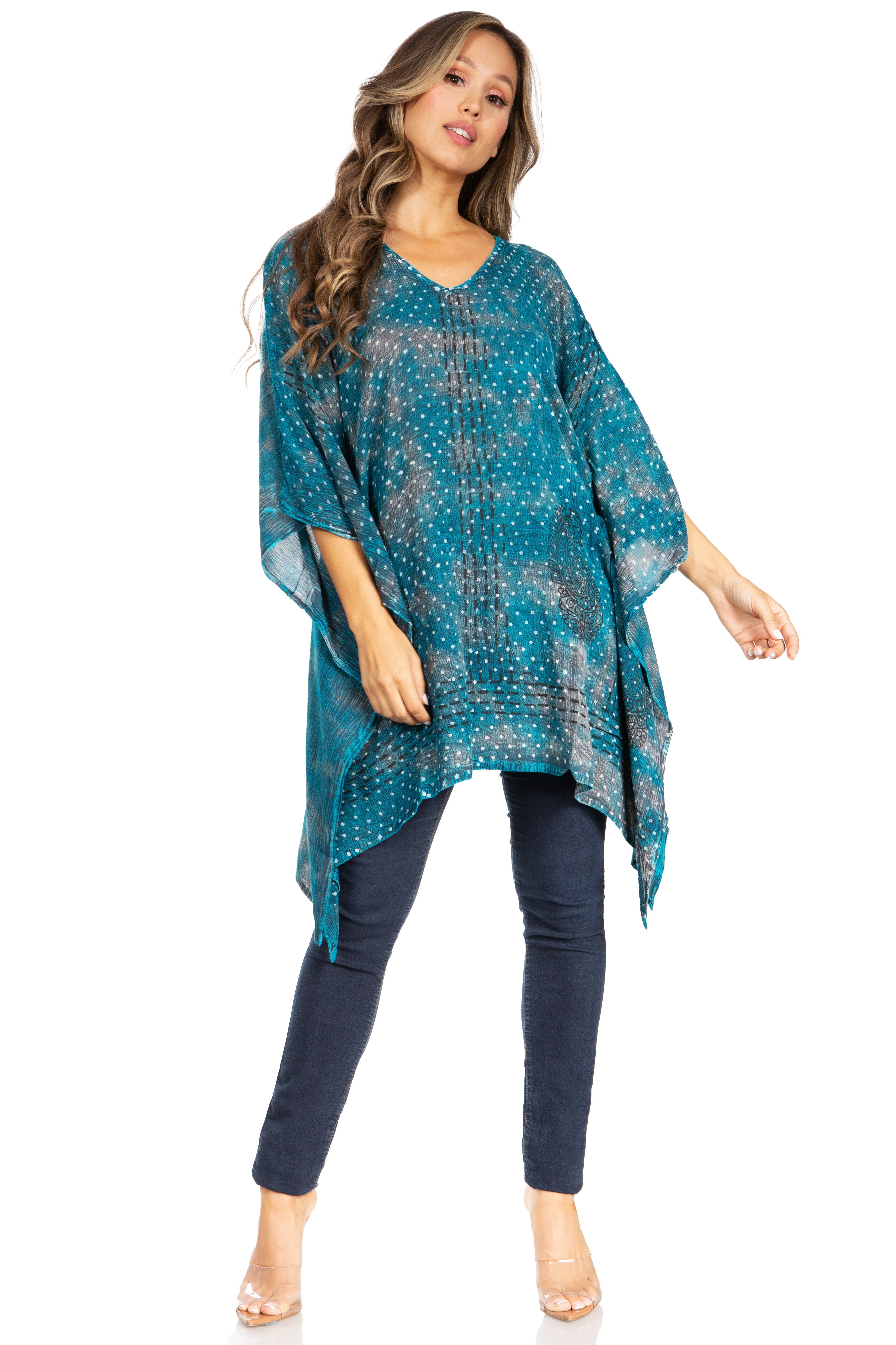 Woman wearing a blue patterned poncho over a dark blue outfit on a white background
