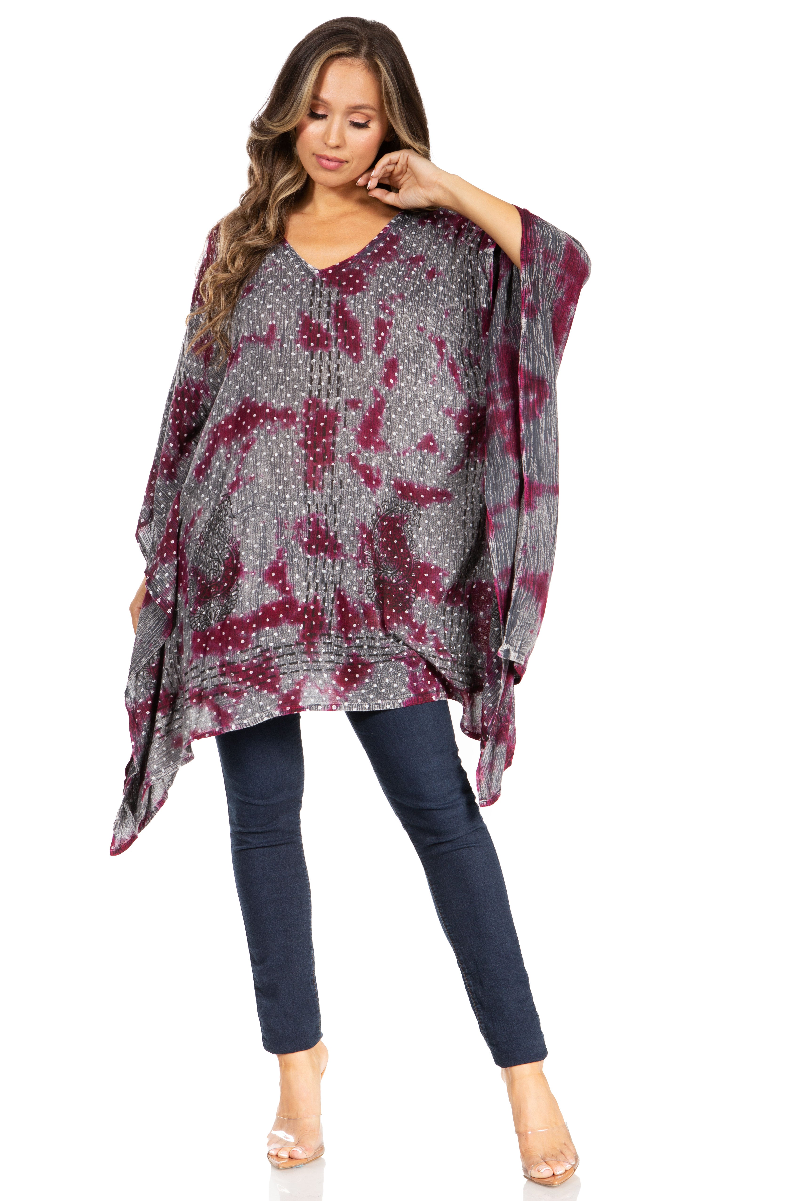 Woman wearing a patterned poncho over a plain background