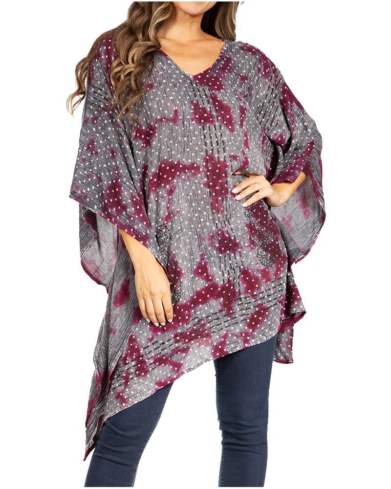 Woman wearing a patterned poncho over a plain background