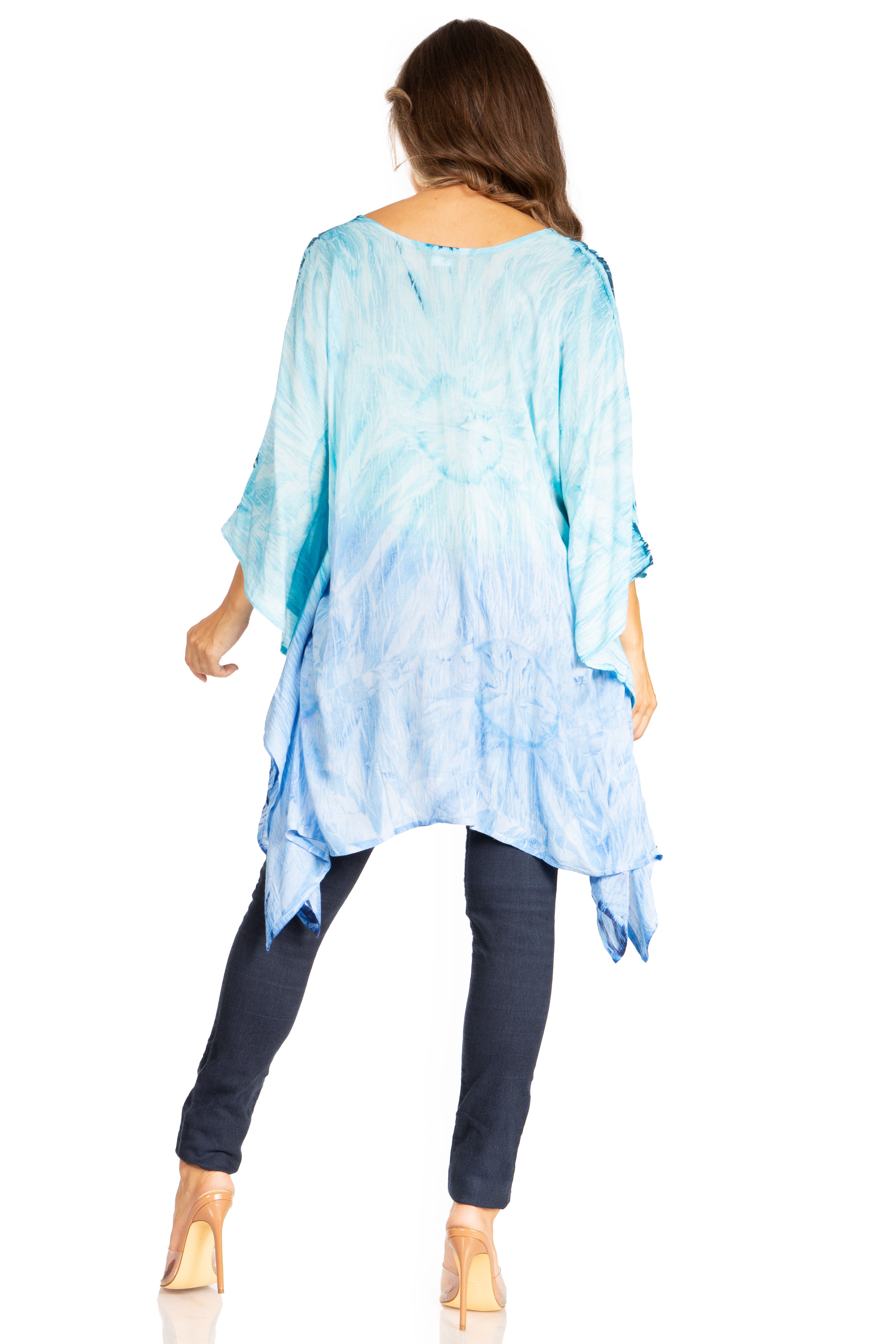 Woman wearing a blue tie-dye top and dark pants on a white background