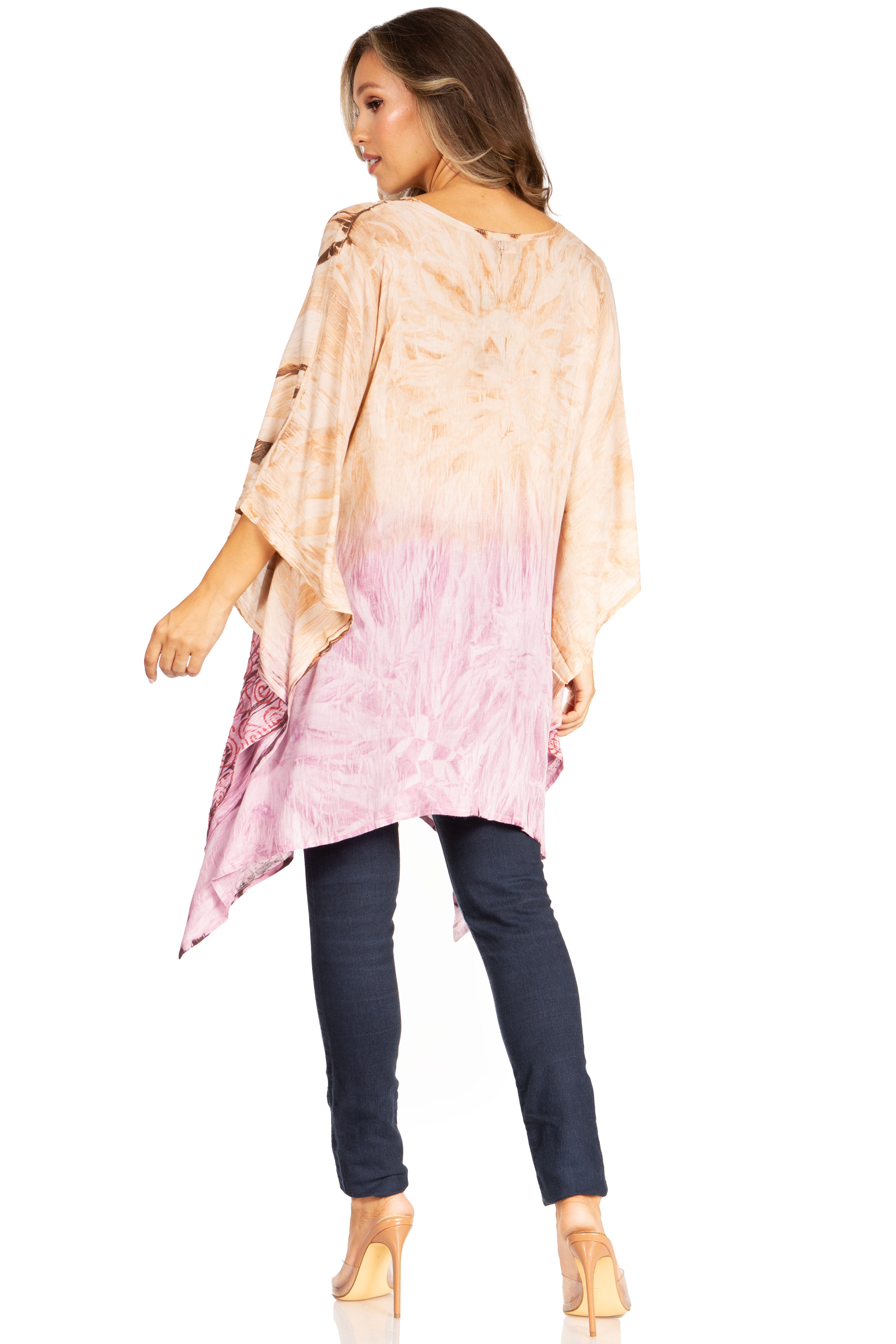 Woman wearing a tie-dye shirt with a gradient from pink to beige, paired with dark jeans on a white background.