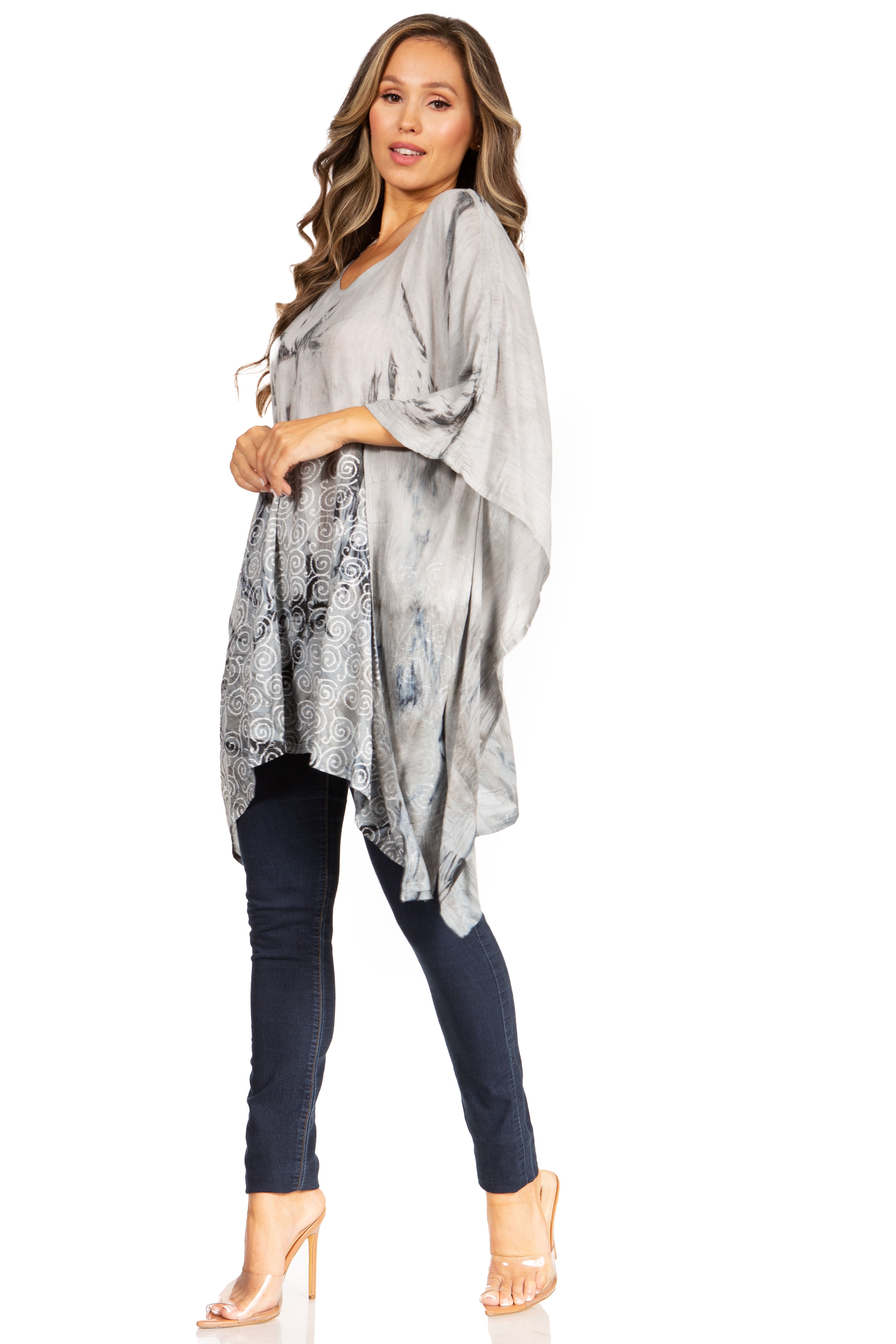 Woman wearing a gray patterned kimono-style top with navy leggings on a white background