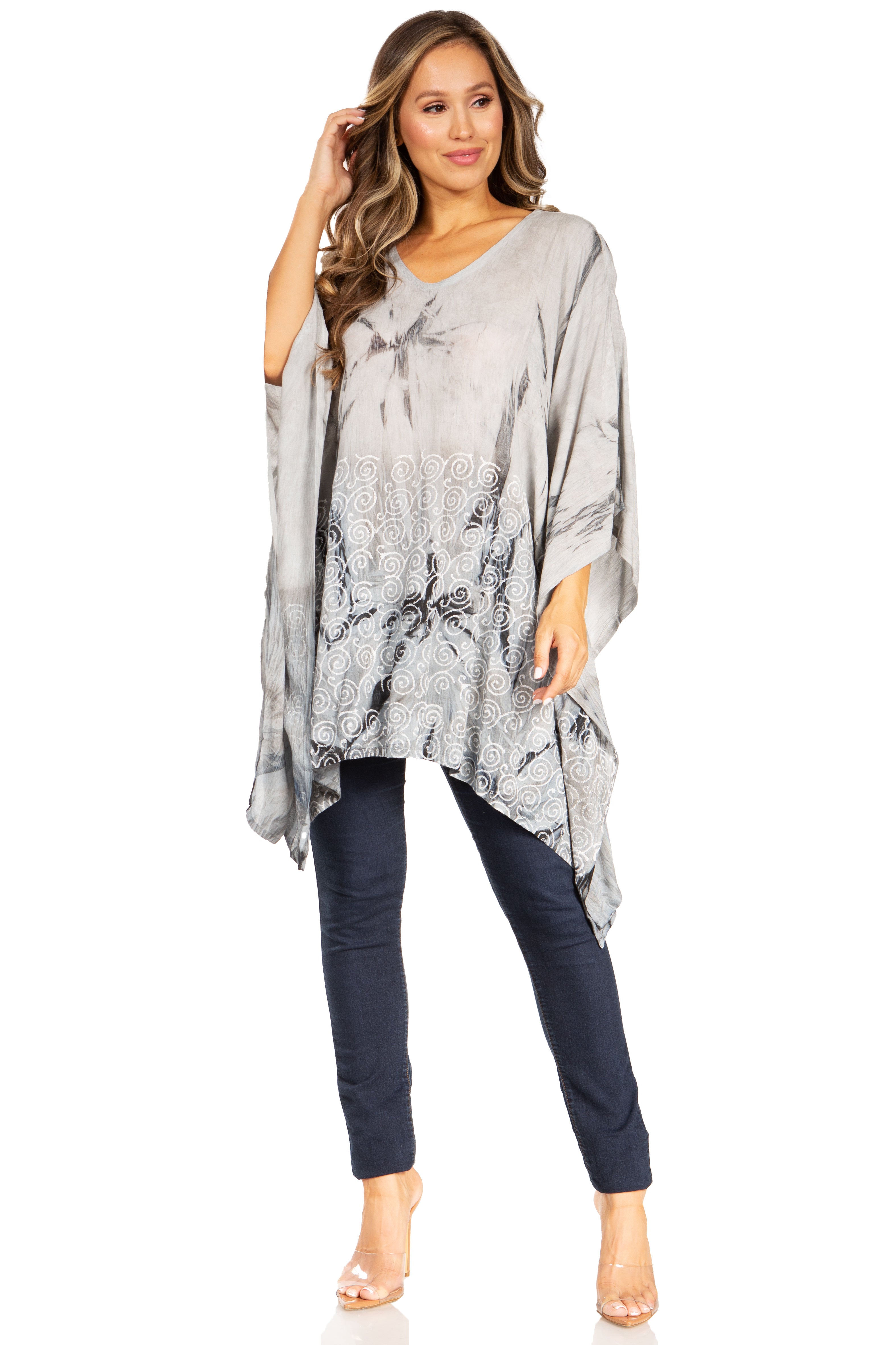 Woman wearing a gray patterned poncho over a navy outfit on a white background
