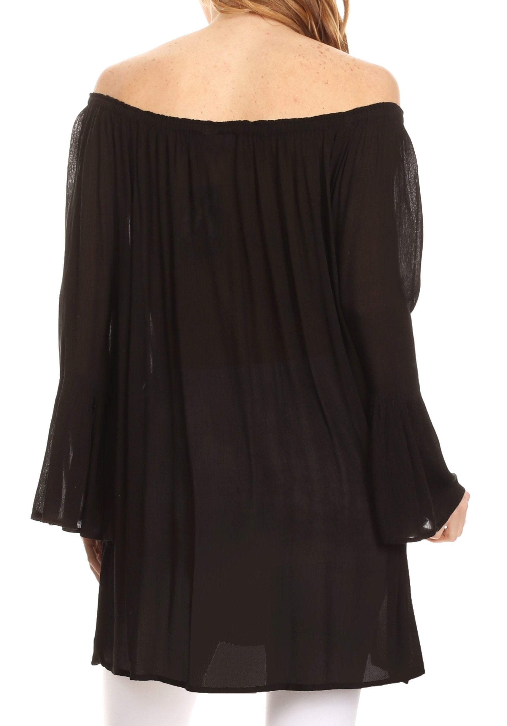 Black off-shoulder top worn by a person on a white background