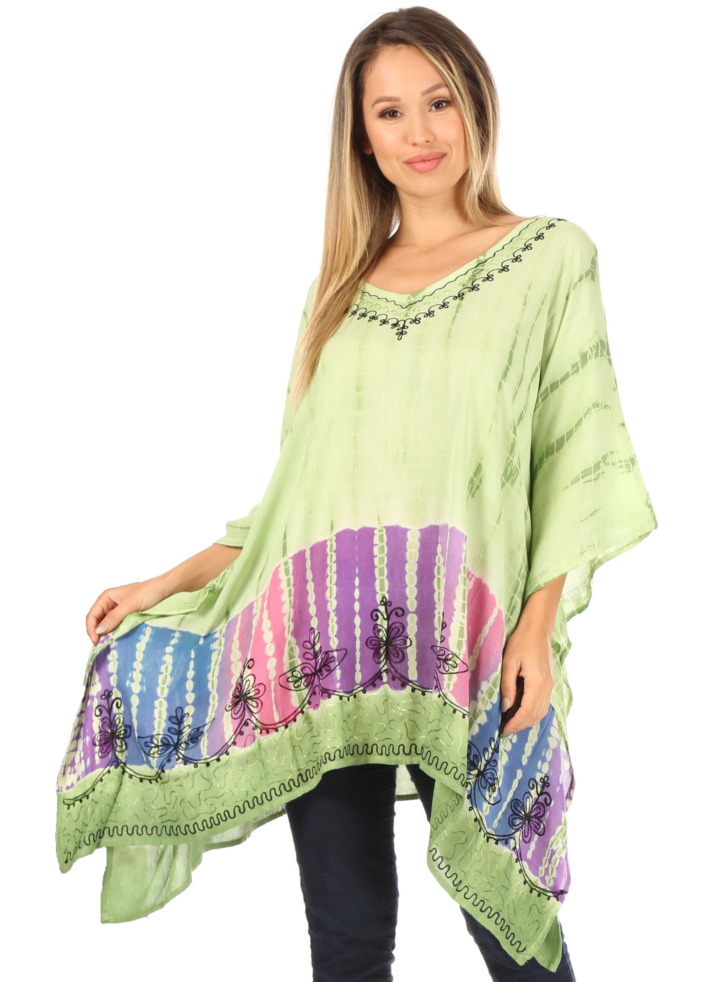 Woman wearing a green poncho with colorful patterns on a white background