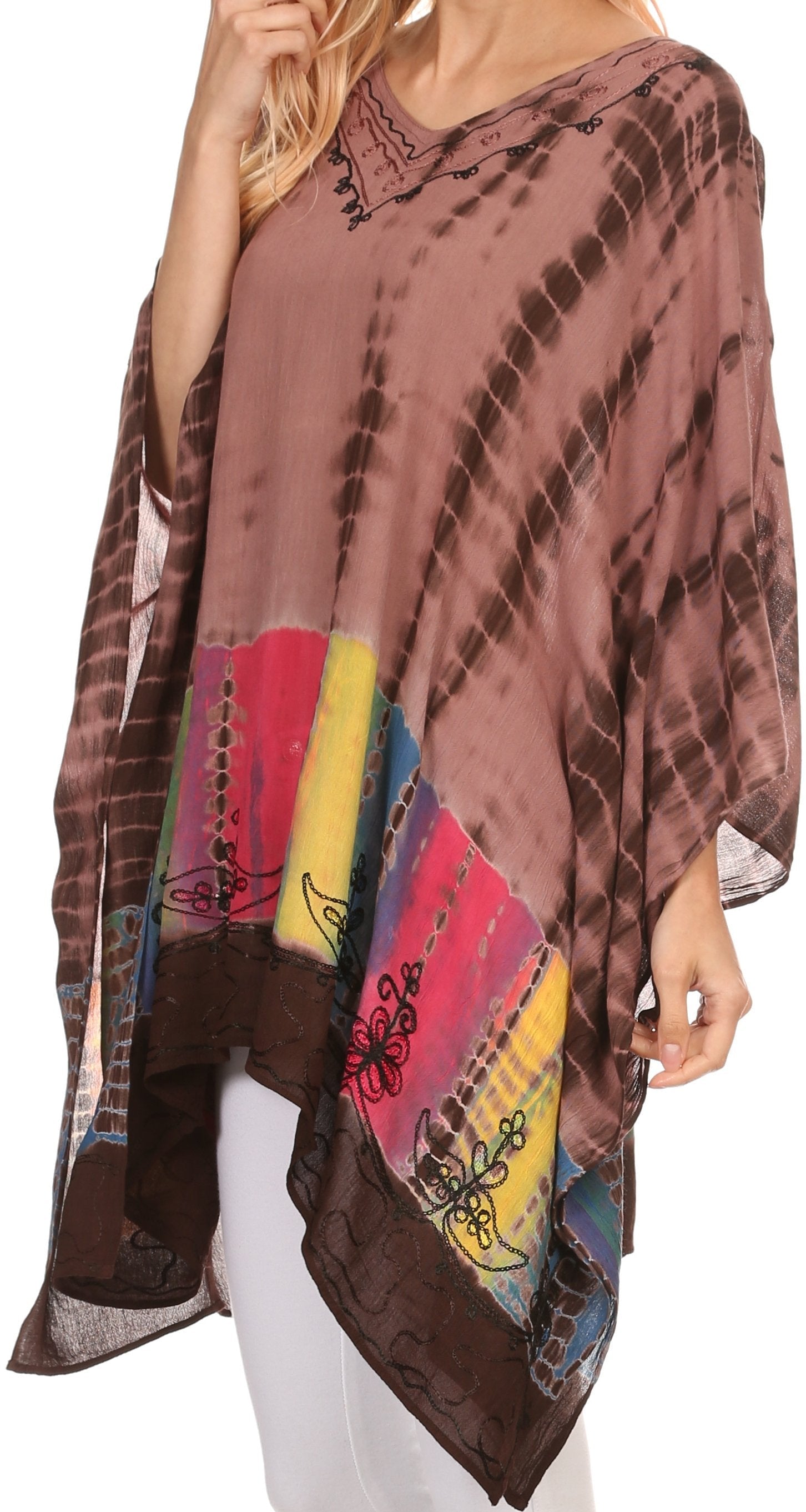 Woman wearing a colorful tie-dye poncho with a pattern of brown, red, yellow, and black.