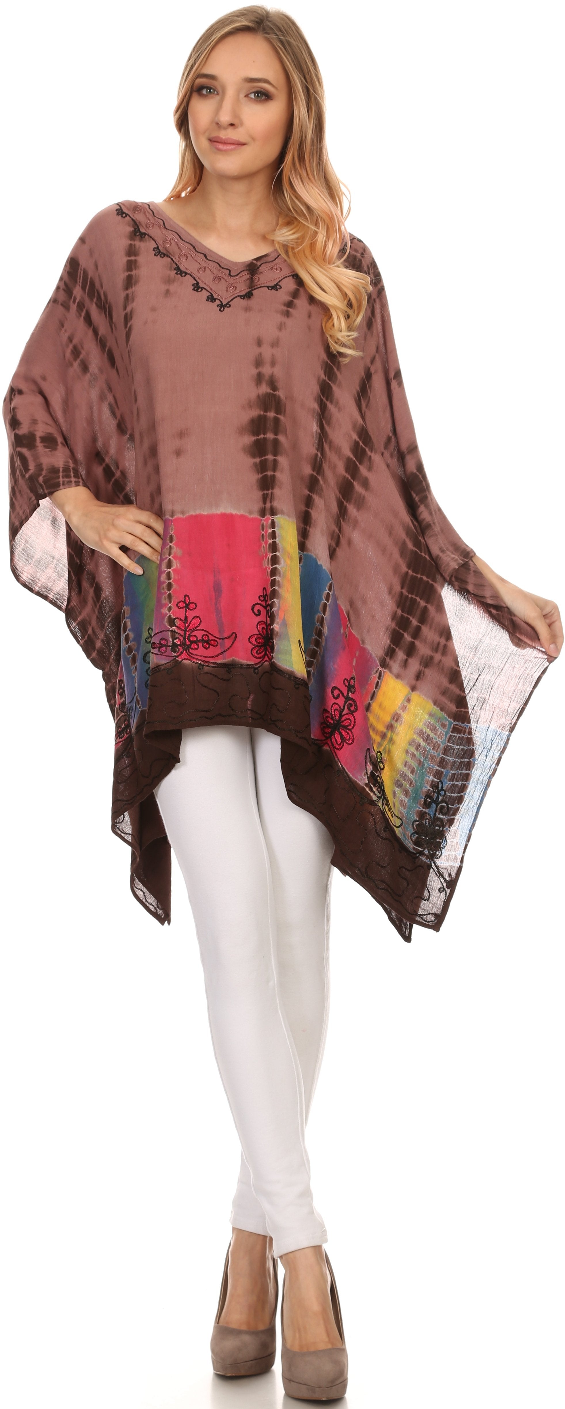 Woman wearing a brown tie-dye poncho over a white outfit on a white background