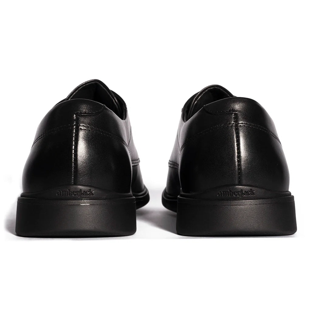 Black leather shoes with 'Timberland' branding on a white background