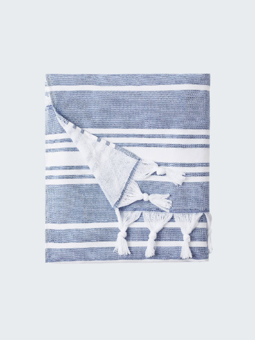 Blue and white striped towel with tassels on a white background