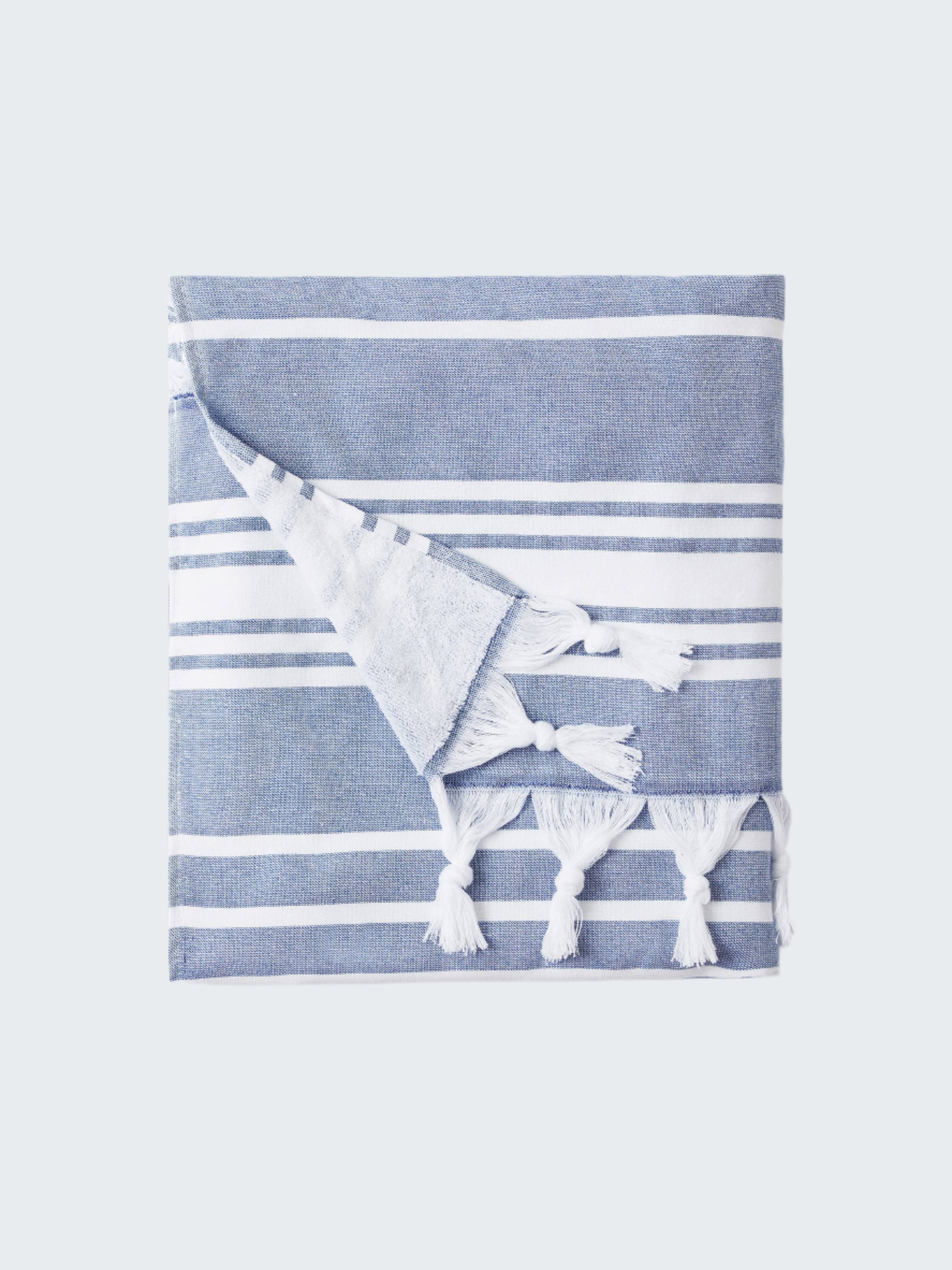 Blue and white striped towel with tassels on a white background