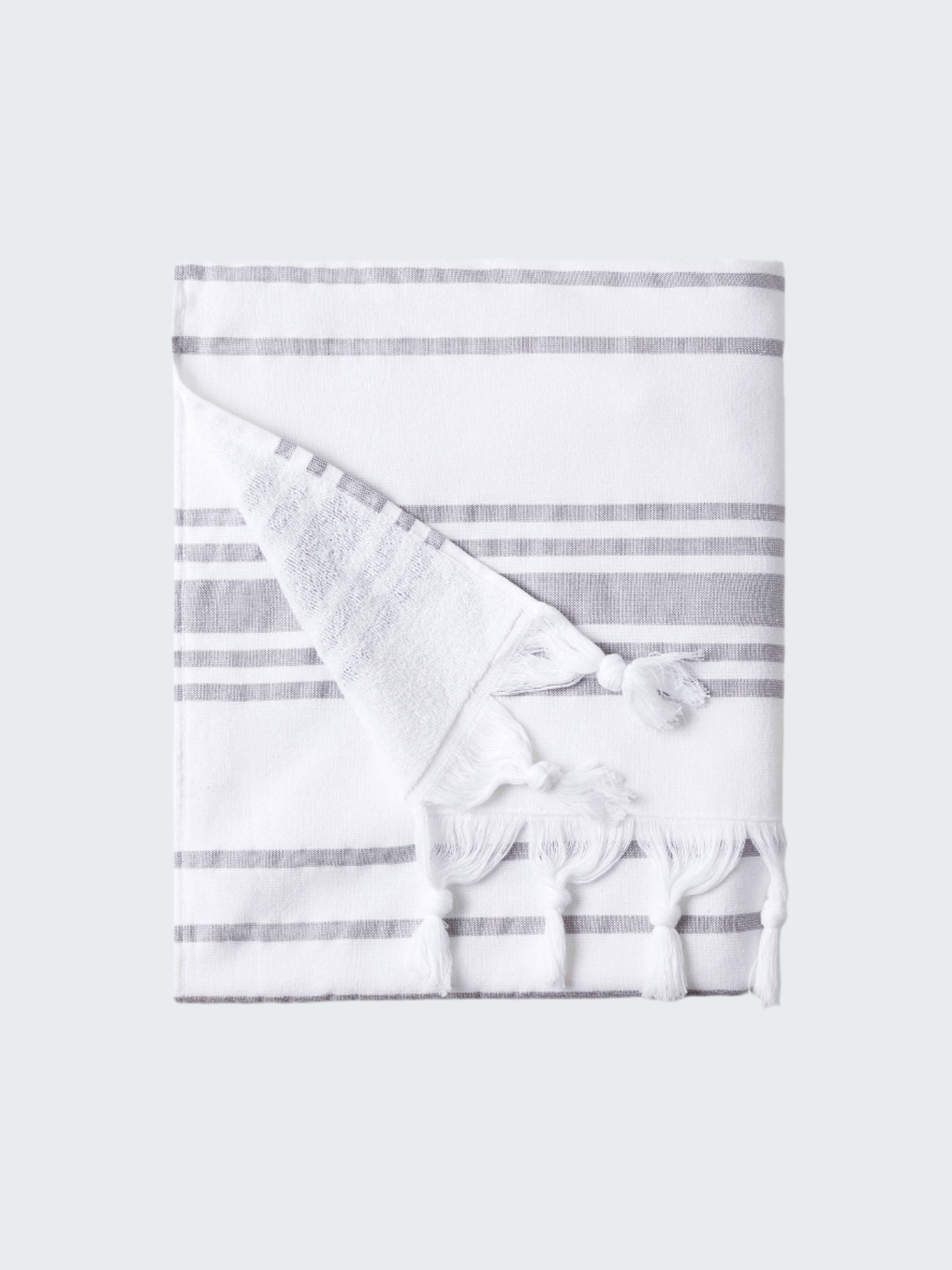 White towel with gray stripes and tassels on a white background