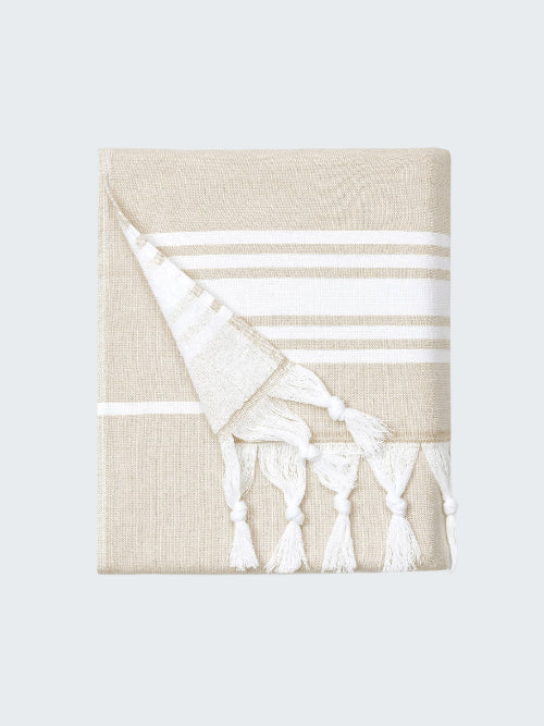Beige towel with white stripes and tassels on a white background