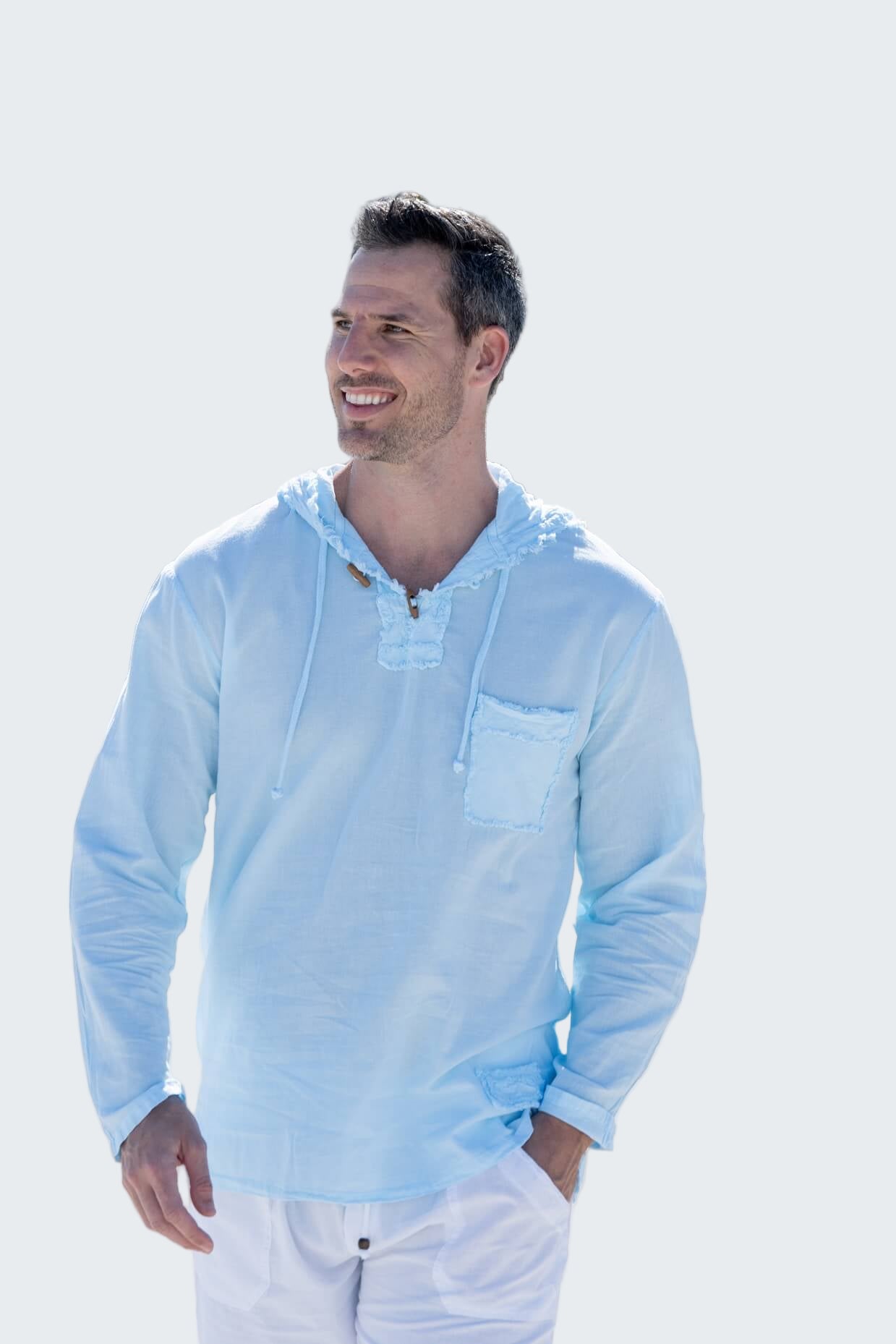 Man wearing a light blue hoodie with a palm tree-lined street in the background