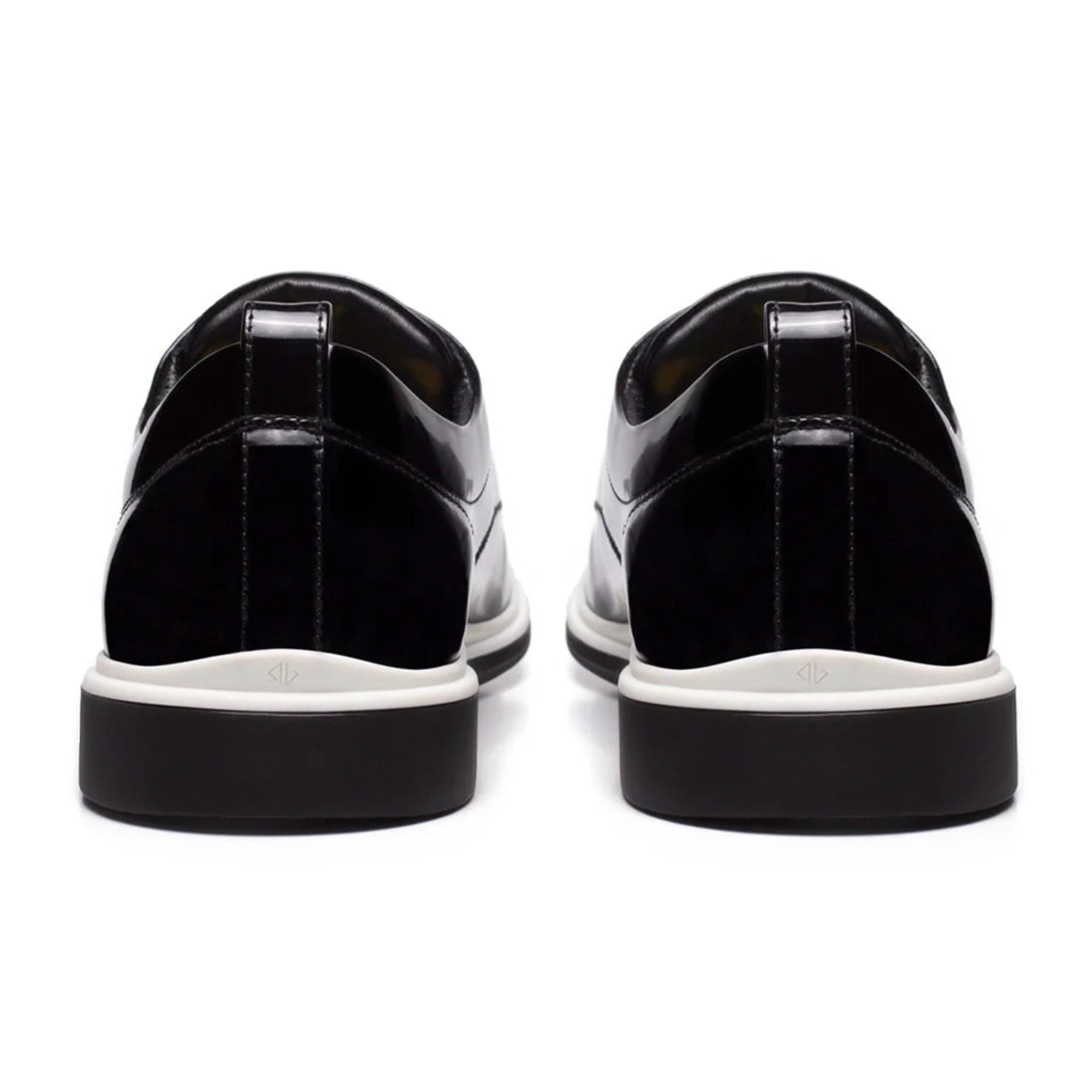Black patent leather shoes with white soles on a white background